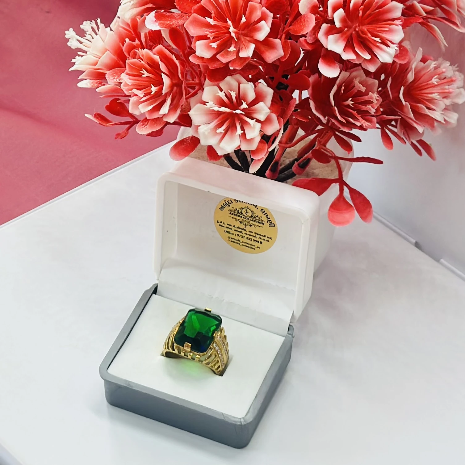 Gold plated men's ring with a green artificial stone and white artificial diamonds.