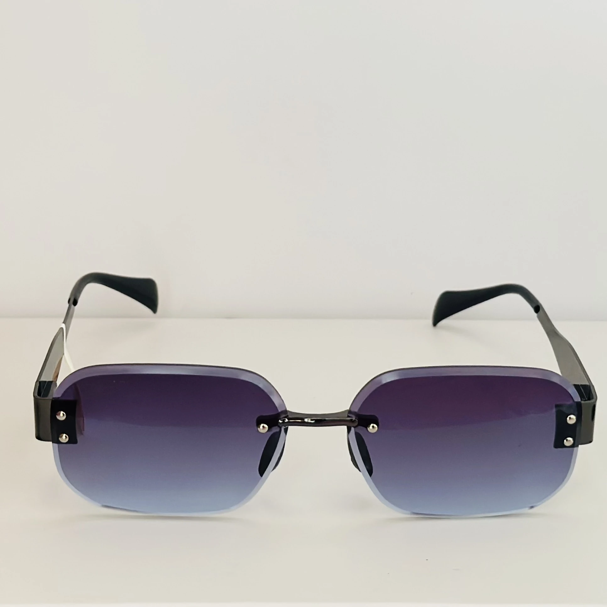 Frameless cut-edge sunglasses with black temples and a gradient tint.