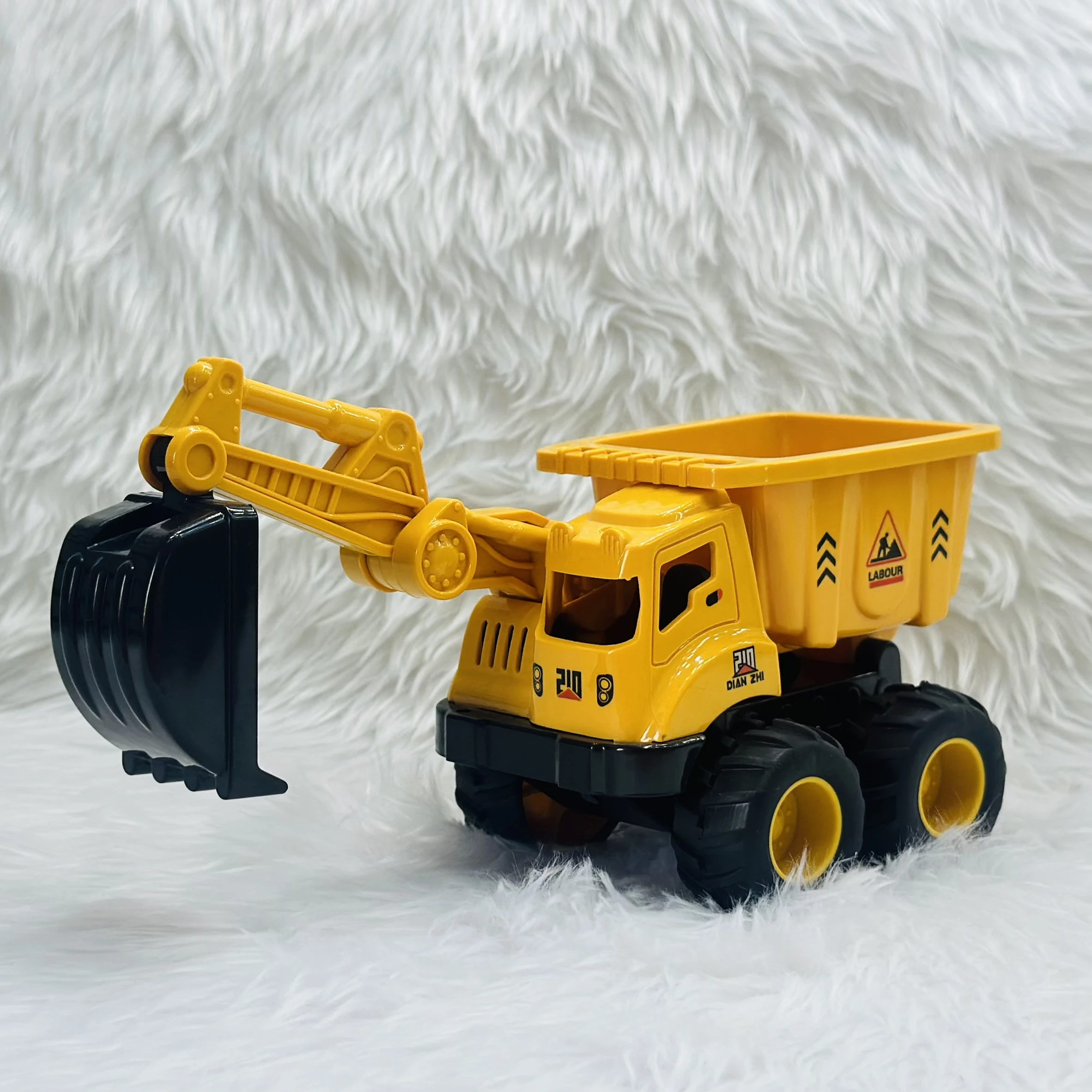 Yellow plastic toy construction vehicle, specifically a 2-in-1 friction-powered dumper and excavator truck.
