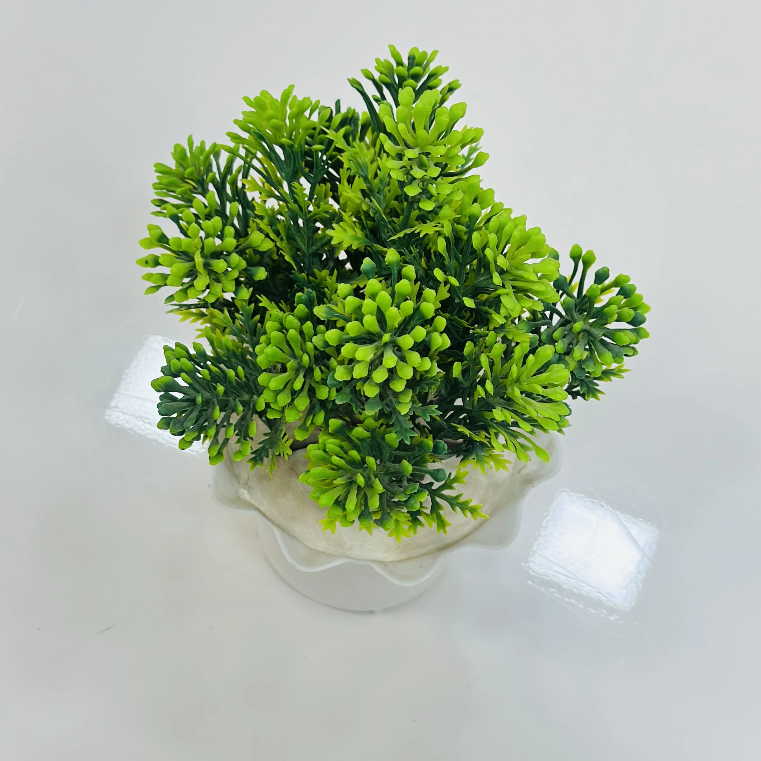 small, artificial potted plant, likely made from plastic materials.