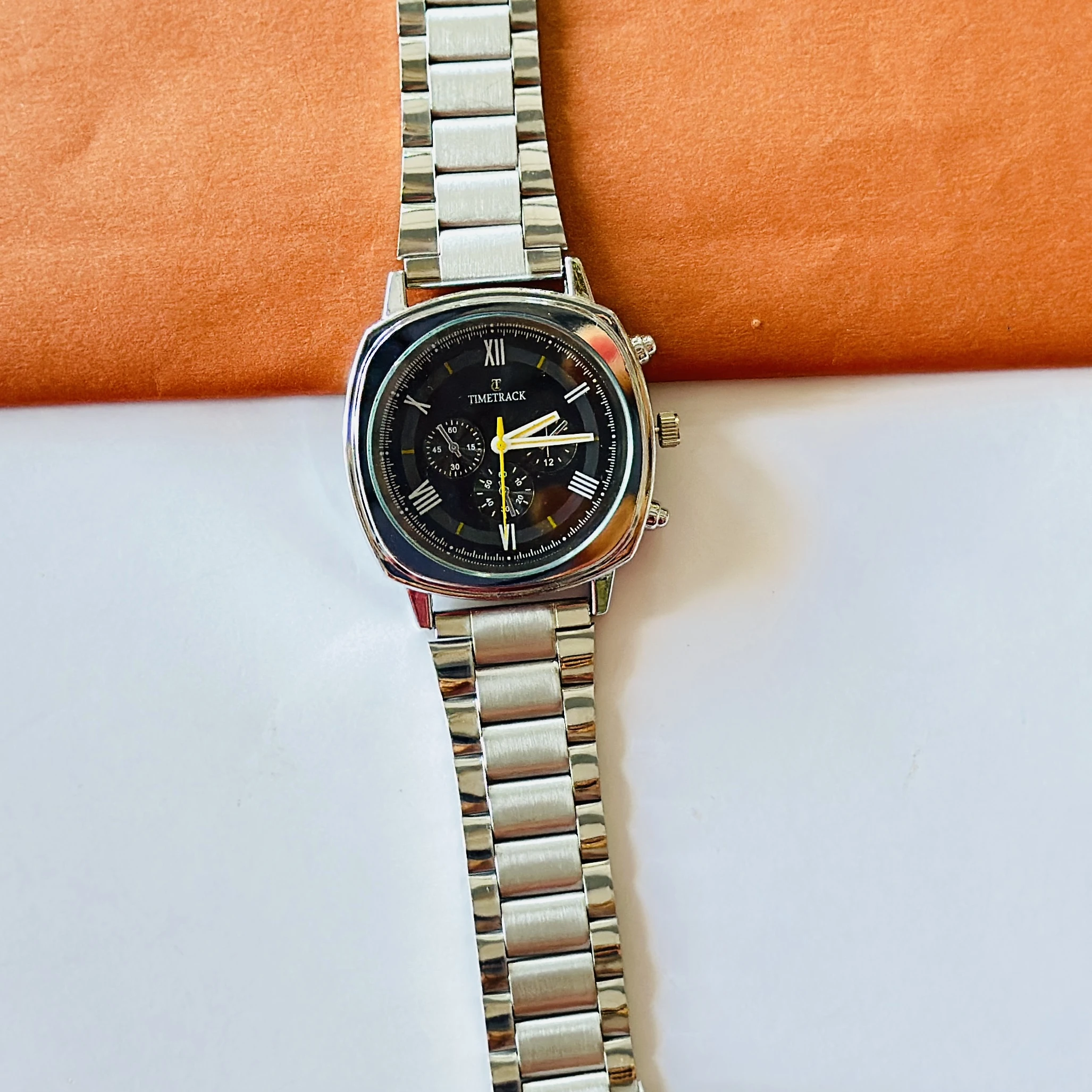 Timetrack brand analog watch with a square case and a stainless steel strap.