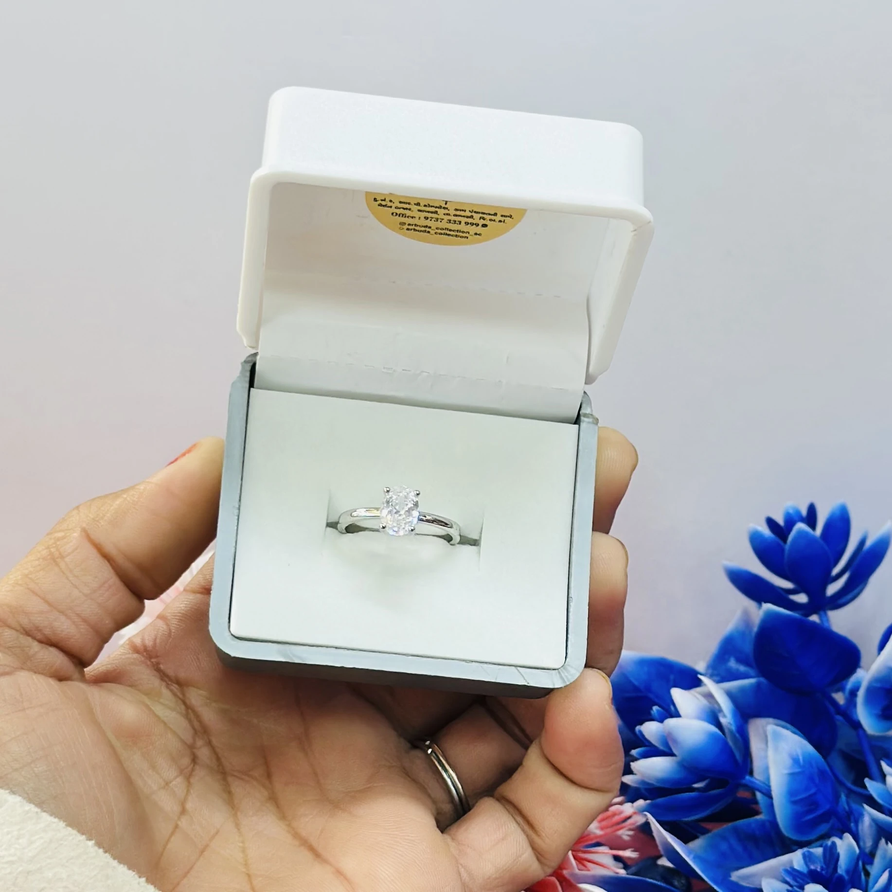 silver solitaire ring with a moissanite stone.