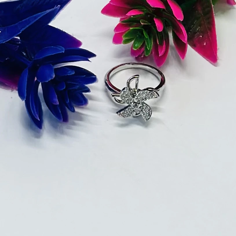 silver floral-shaped ring adorned with sparkling cubic zirconia or diamonds.