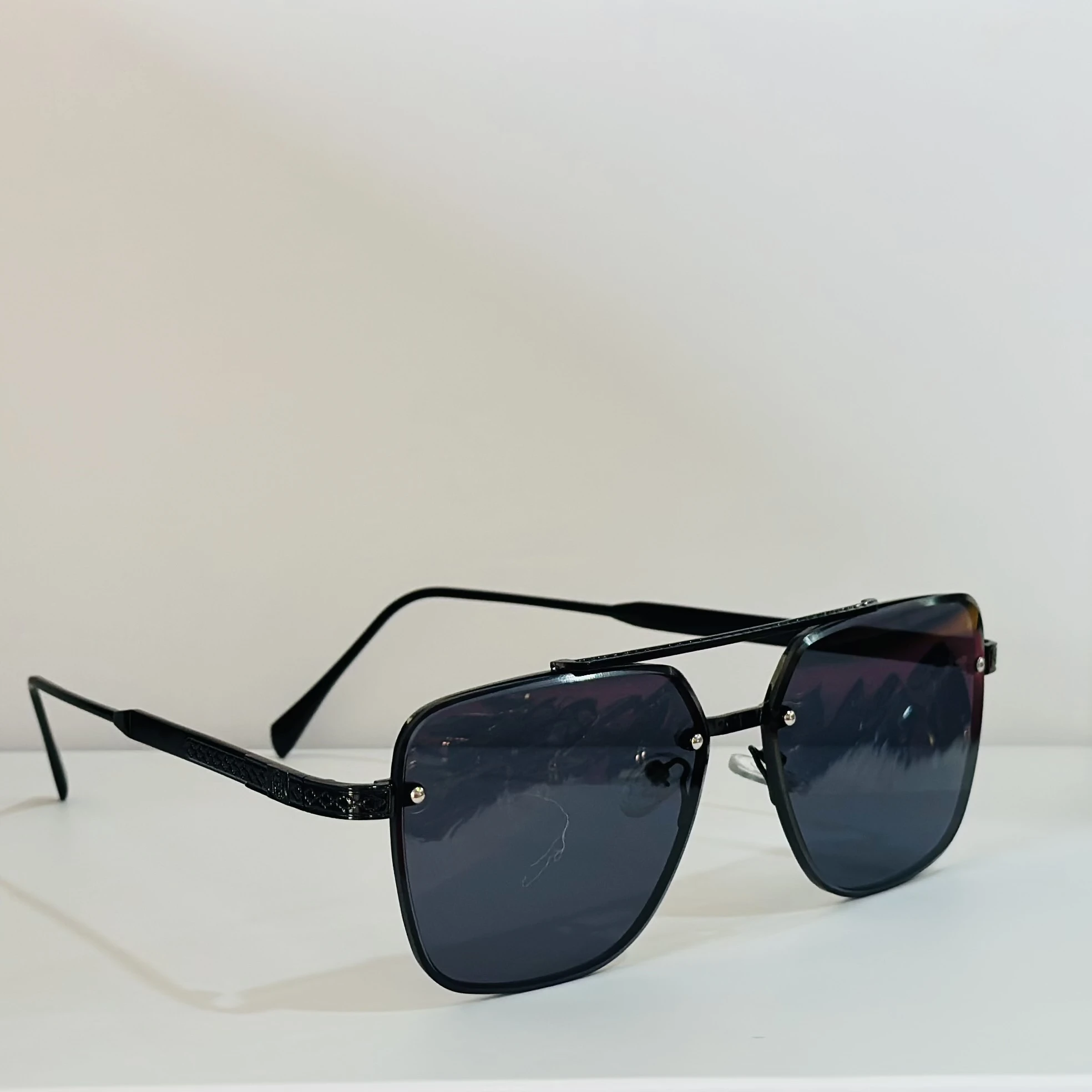 pair of MOONX Celebrity black UV protected sunglasses with a black frame.