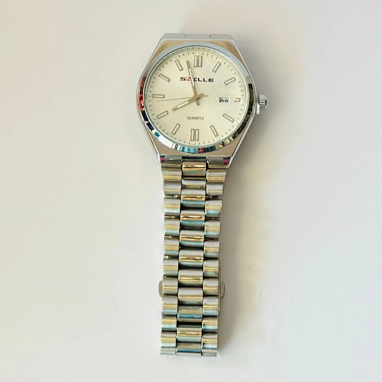 Snille analog quartz watch with a white dial and silver stainless steel strap.