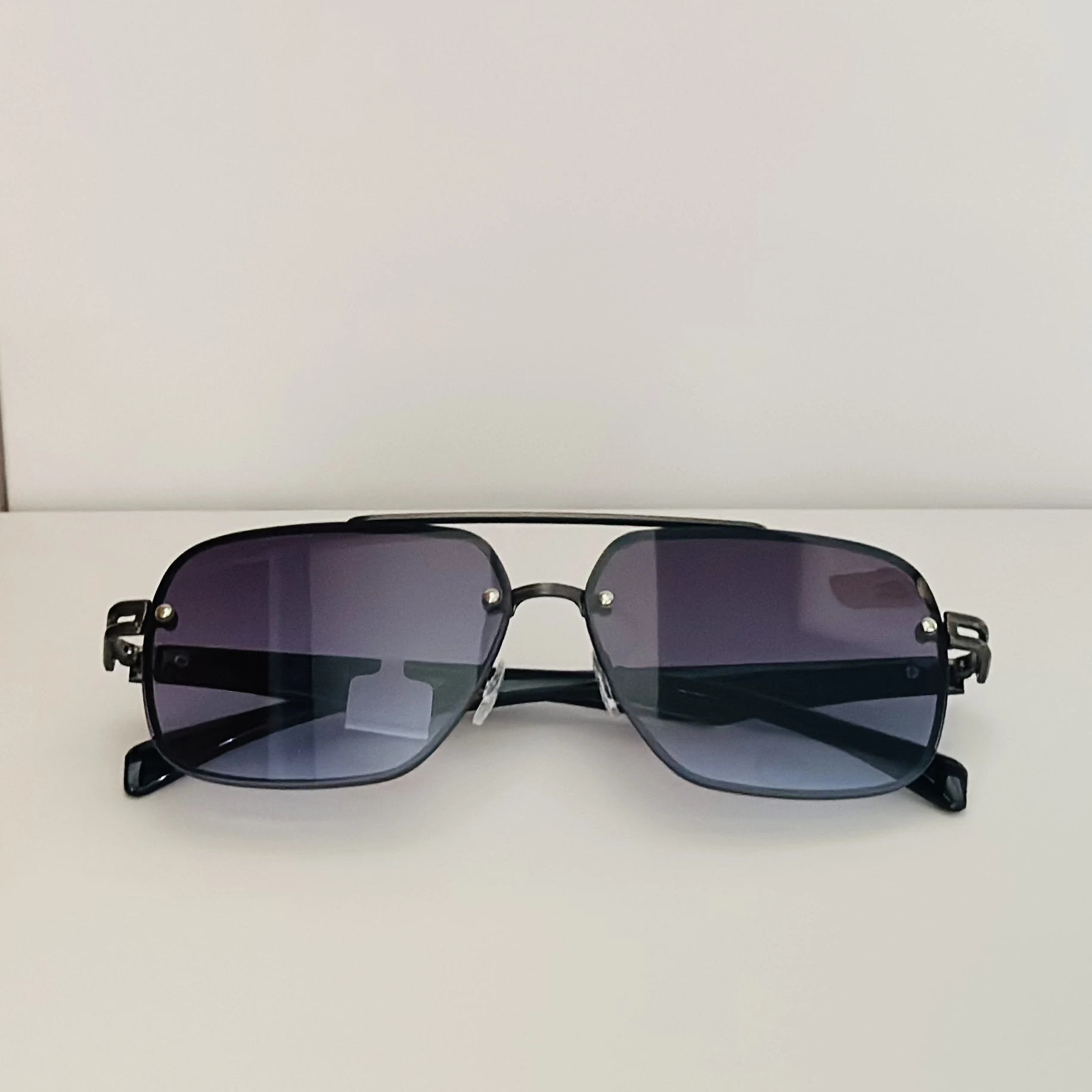 black rimless aviator sunglasses with blue gradient lenses.