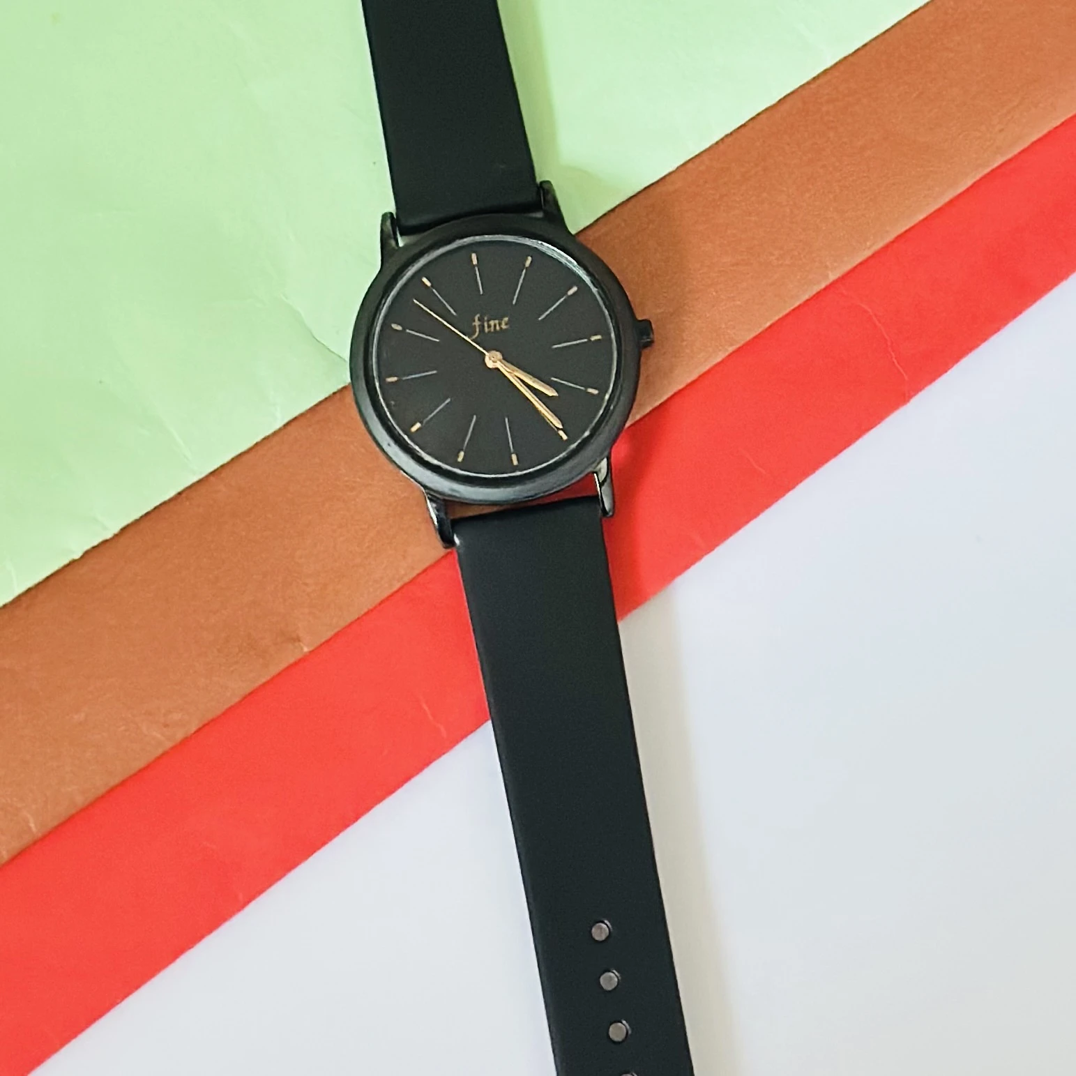 women's analog watch in black with a silicone strap.