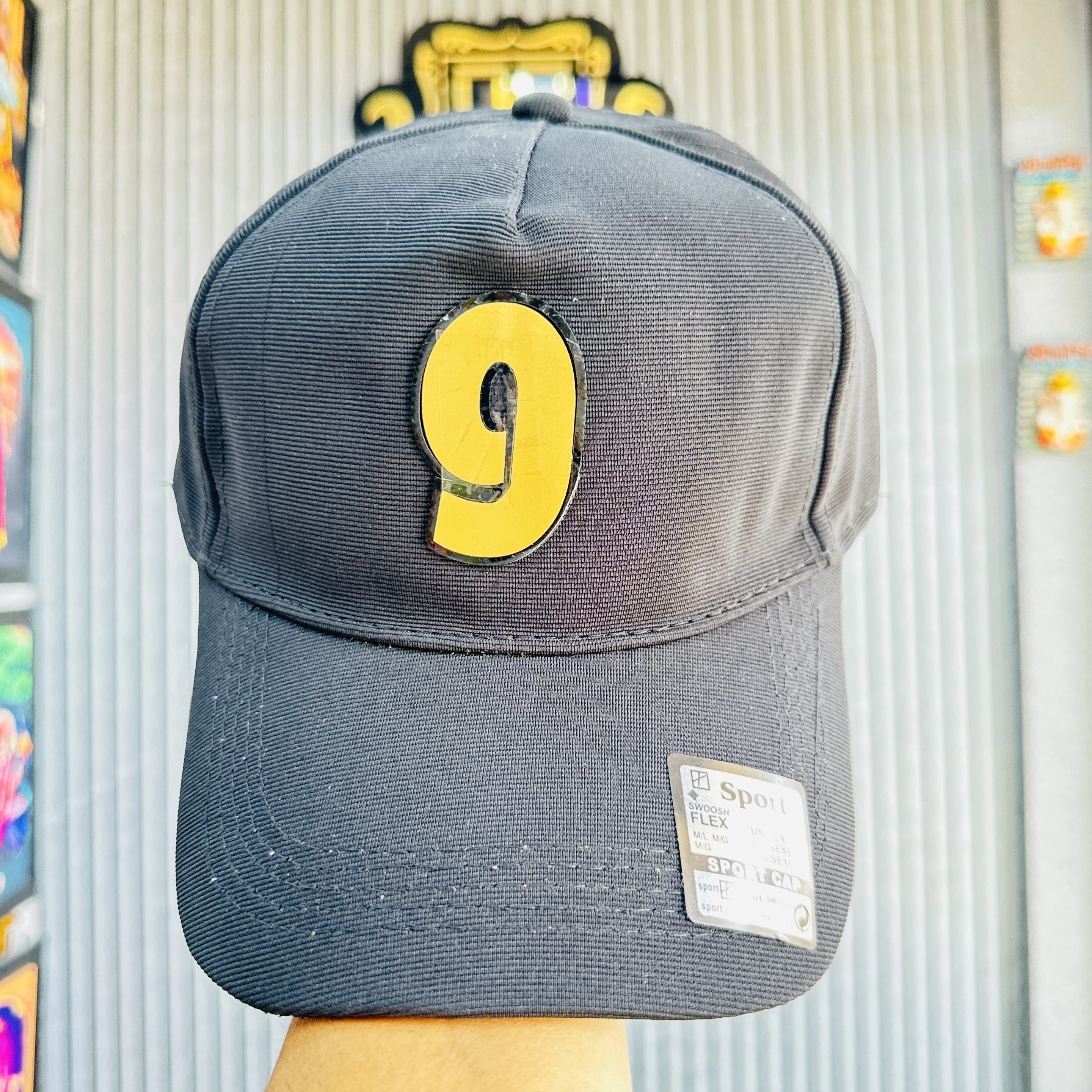 cap features a prominent yellow and black number '9' patch on the front.