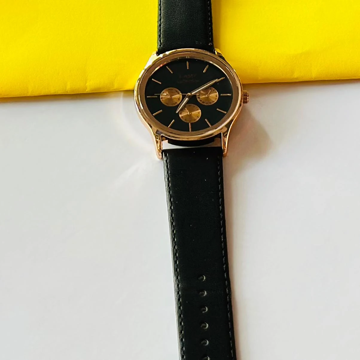 Round analog watch with a black leather strap