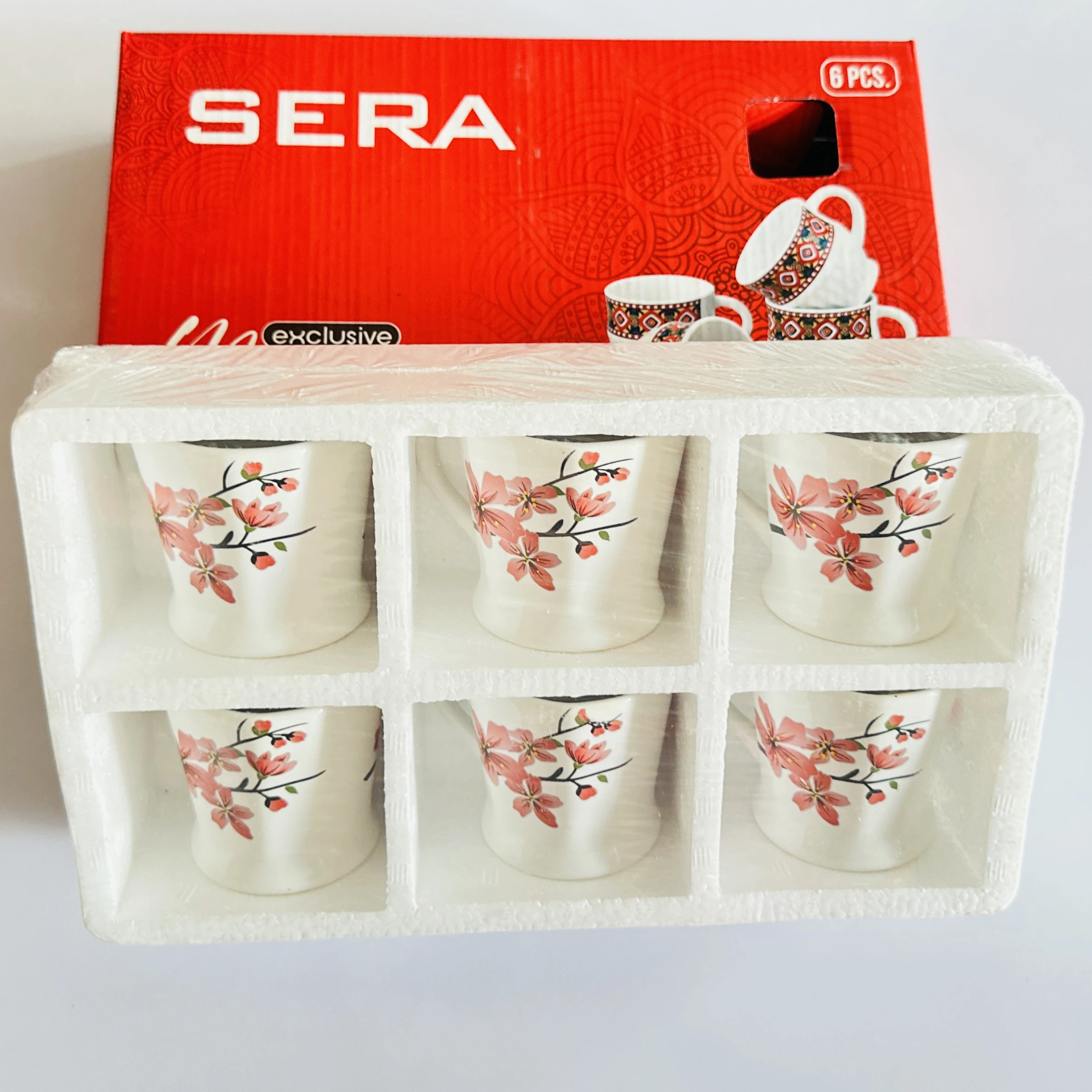 set of six Sera branded ceramic coffee mugs featuring a floral design.….IC85LY