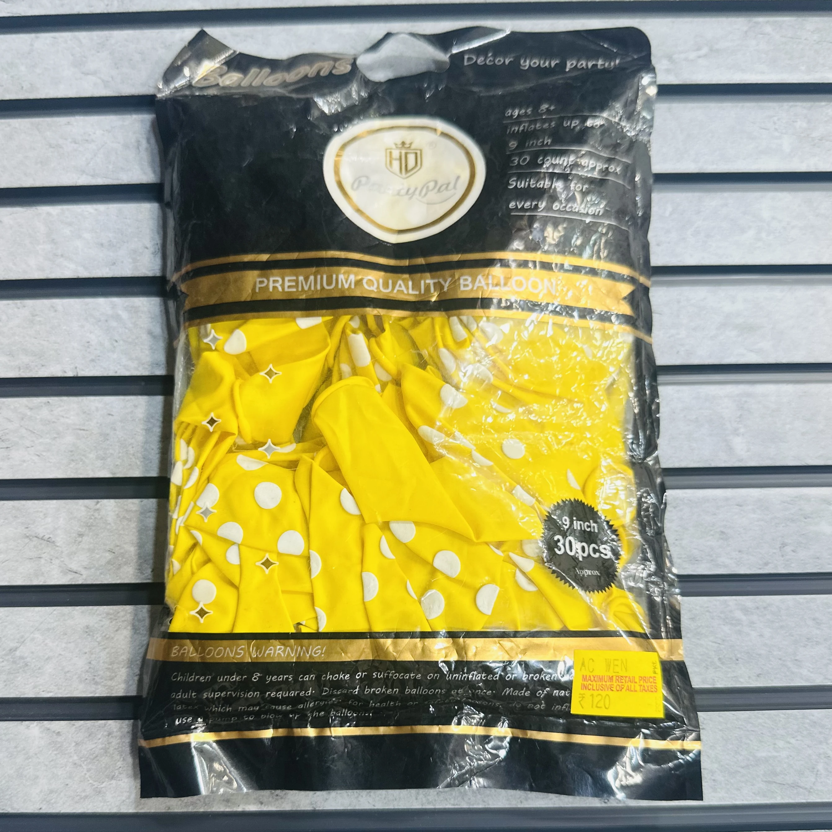 package of Yellow party balloons with white polka dots.