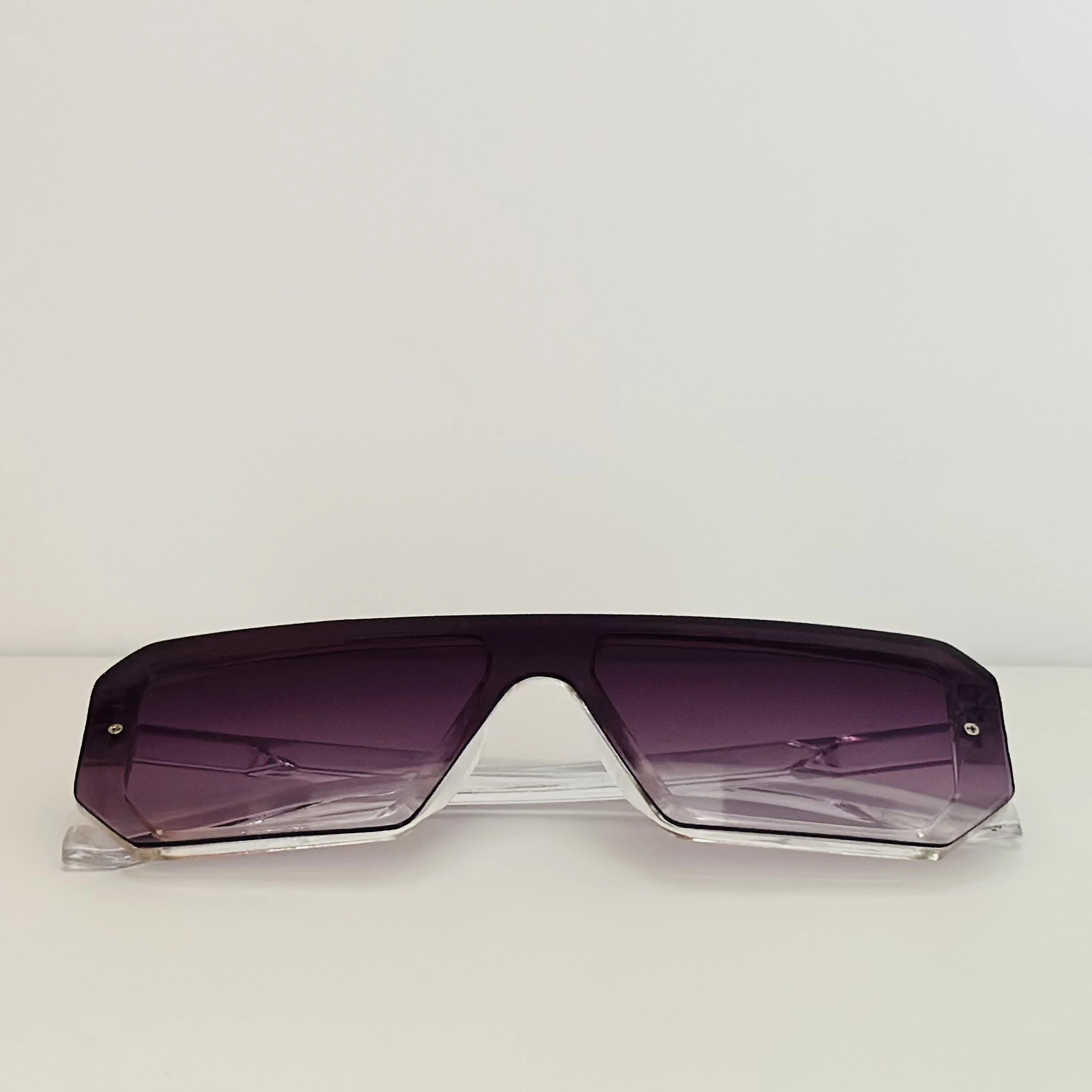 Oversized shield sunglasses with a rimless, flat-top design and purple gradient lenses.
