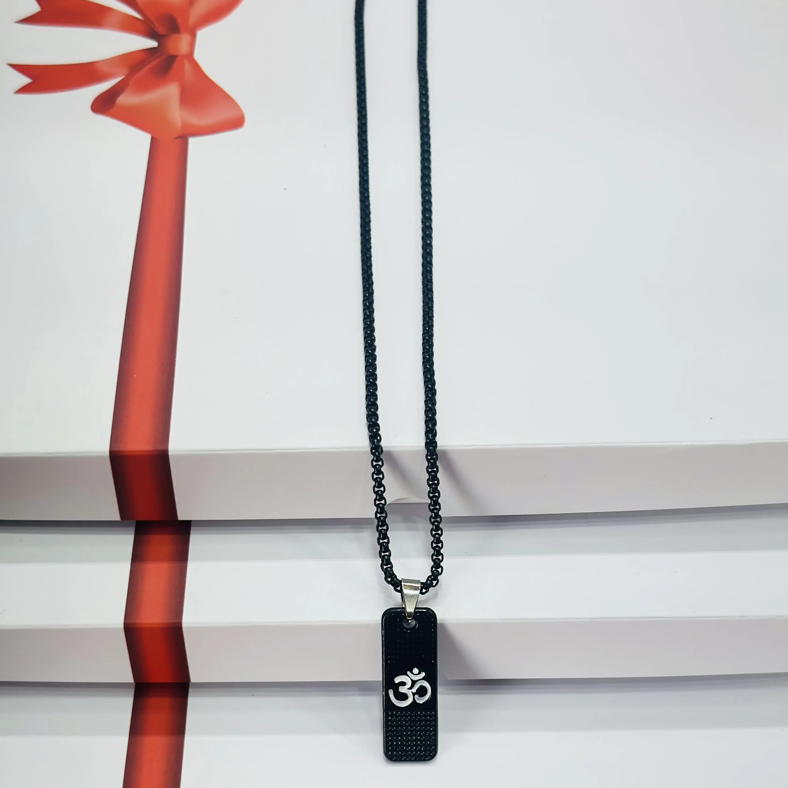 Black stainless steel pendant necklace with the white Om symbol.