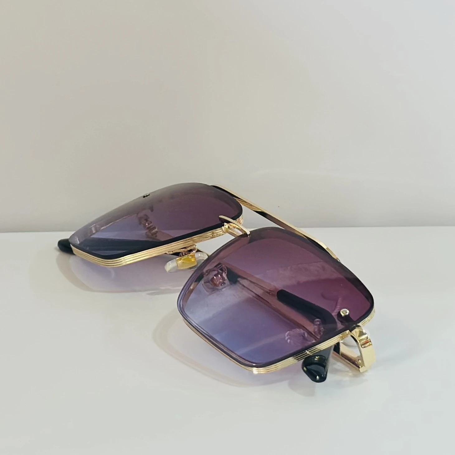 Sunglasses in a gold-tone metal frame with gradient lenses.