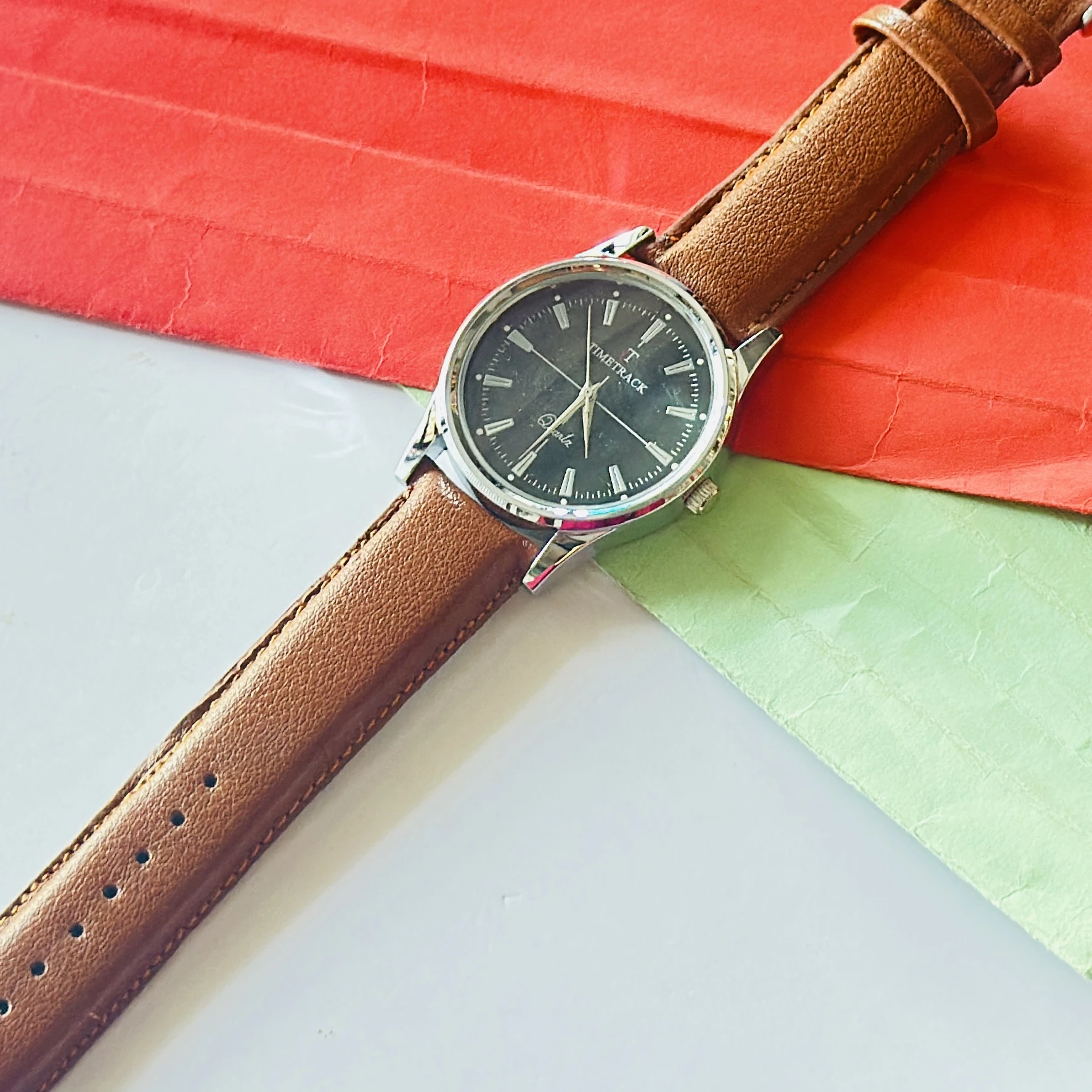 analog watch with a brown leather strap and a silver-toned case.