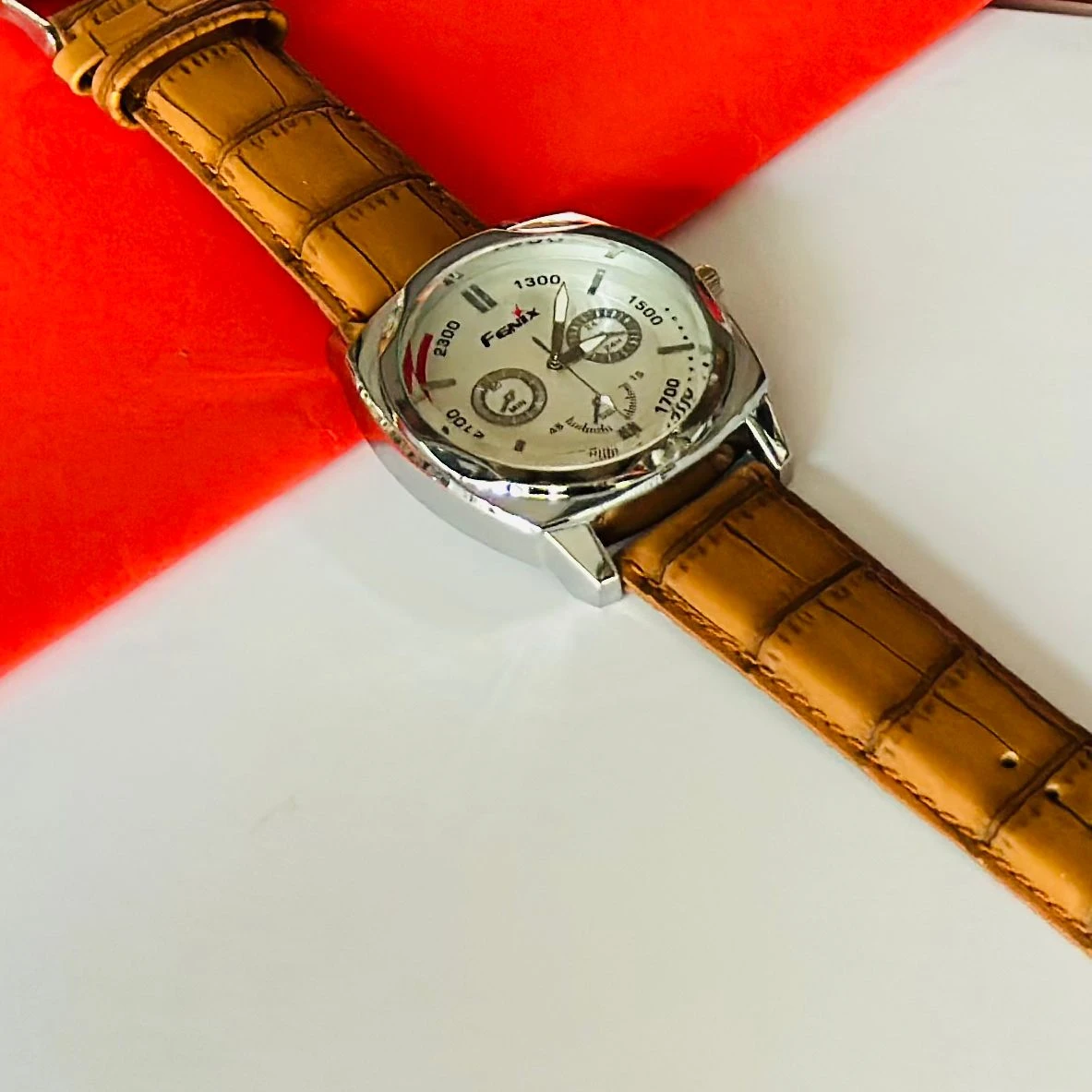 Round analog watch with a brown leather strap