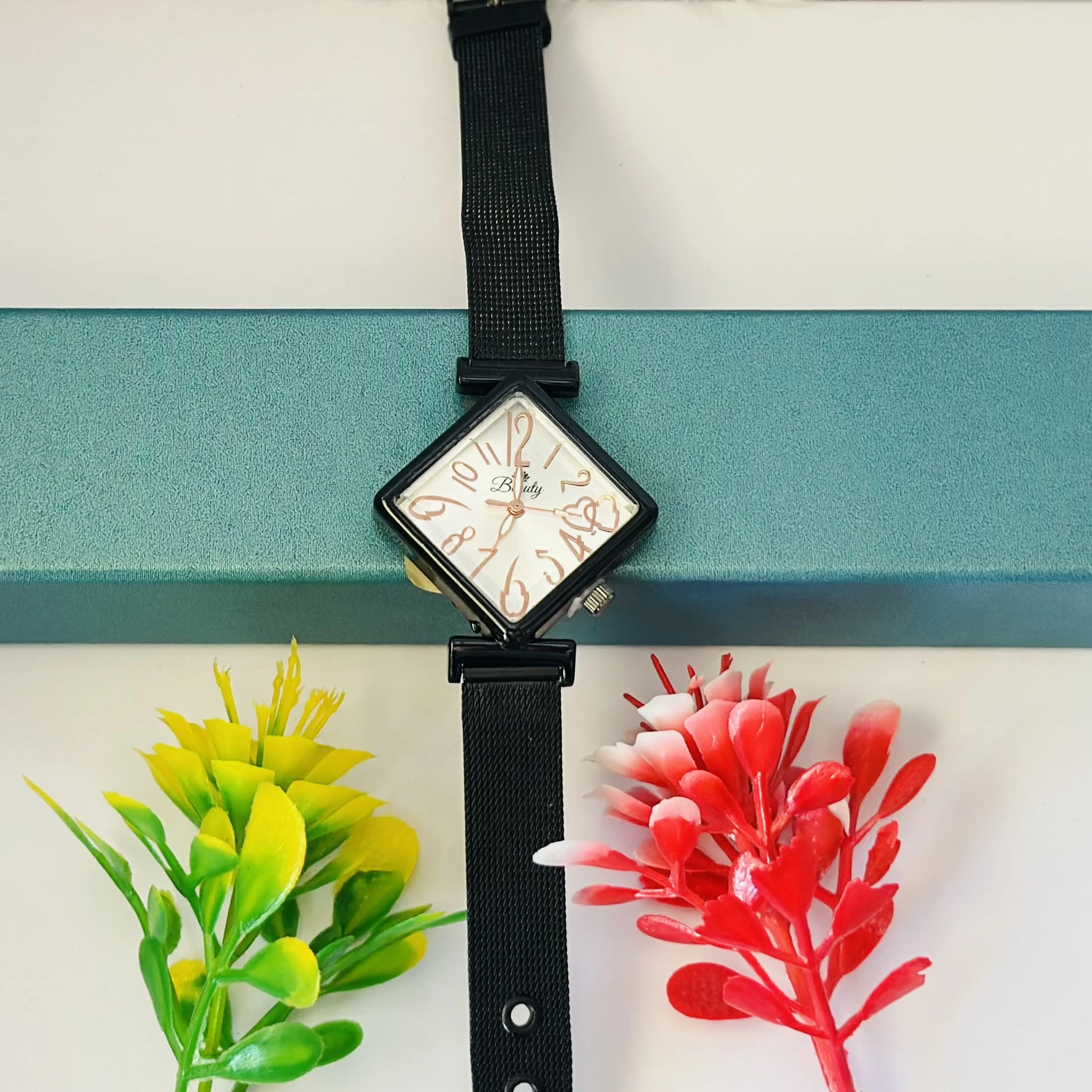 Black mesh strap watch with a square face.