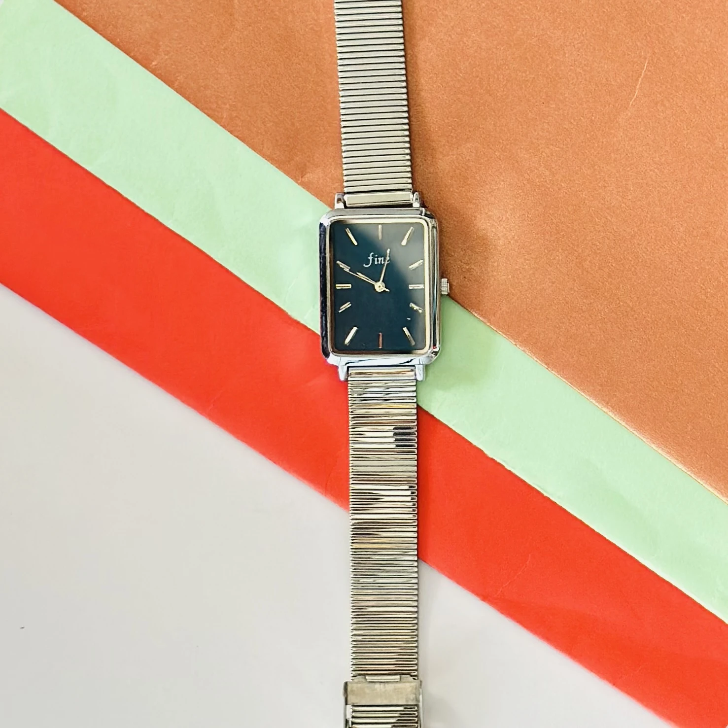 Rectangular Dial analog watch with a mesh strap.
