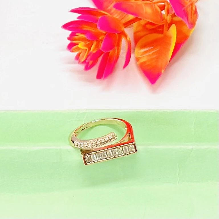 modern minimalist gold ring featuring a baguette diamond bar design.