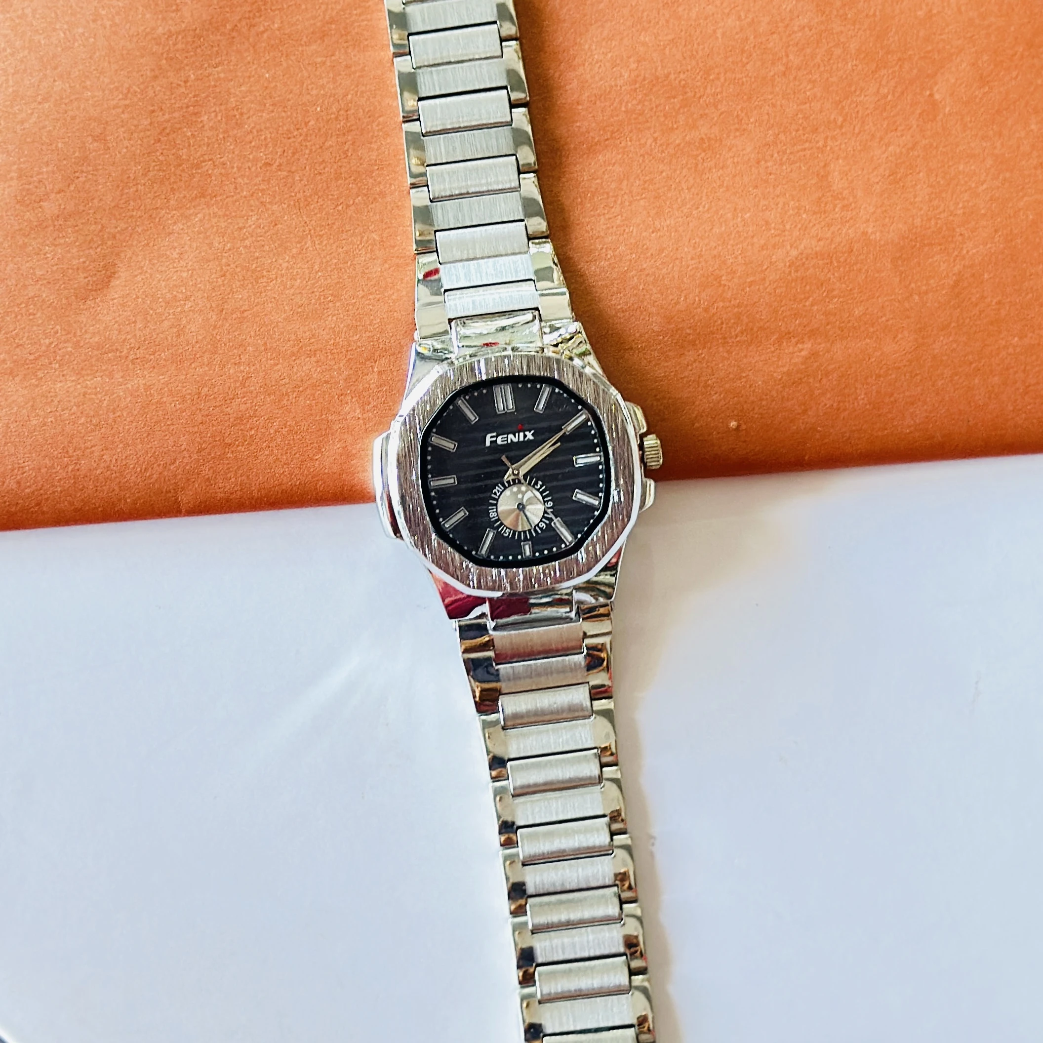 Fenix analog watch featuring a silver-tone stainless steel strap and a black dial.