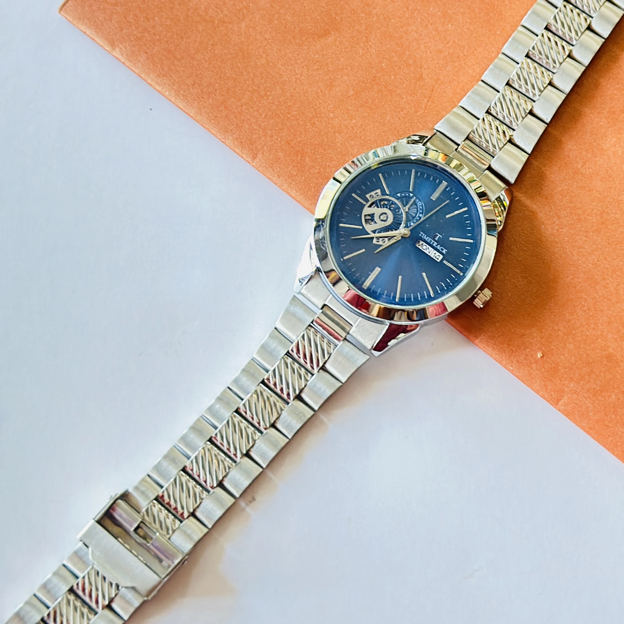 Timetrack stainless steel automatic watch with a blue dial and a bracelet strap.