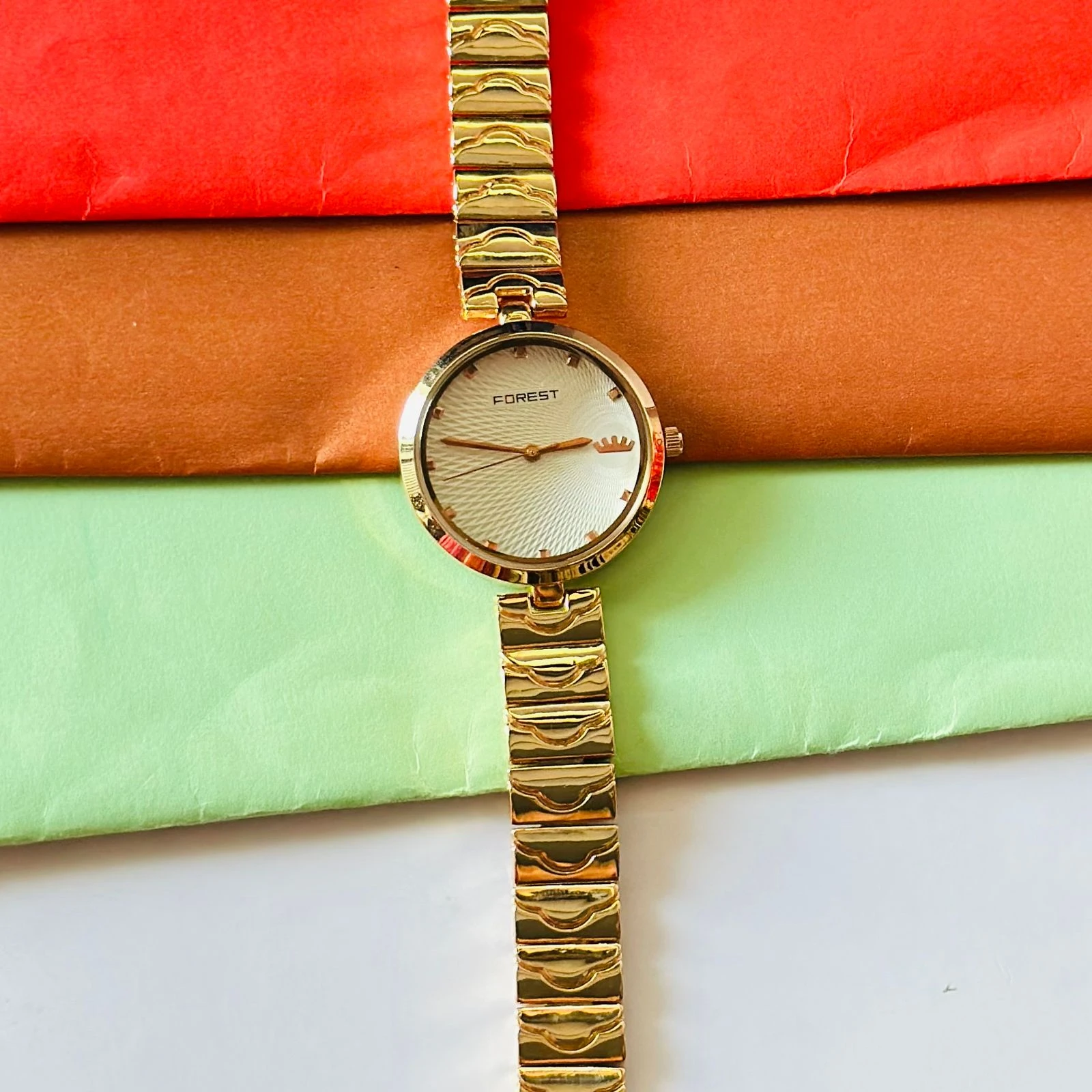 analog watch with a white dial and a rose gold metal strap