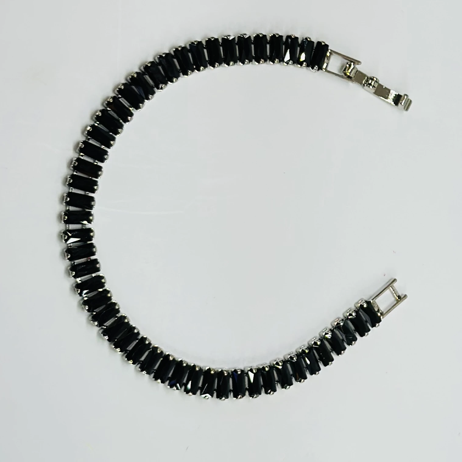 Gold plated black baguette tennis bracelet with artificial stones.