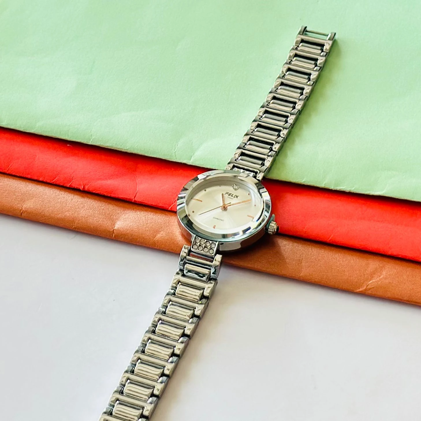 analog watch with a white dial and a rose gold metal strap