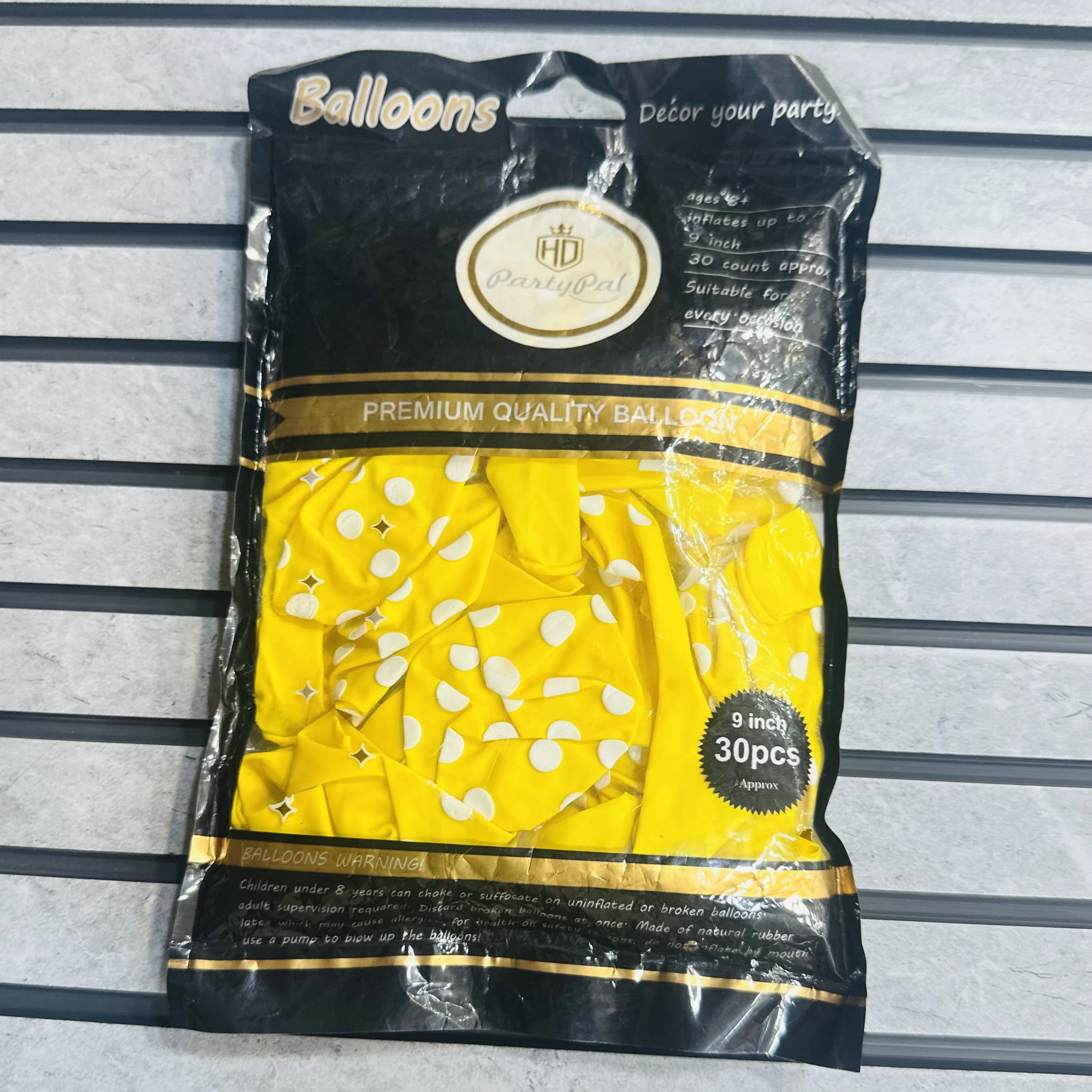 package of Yellow party balloons with white polka dots.