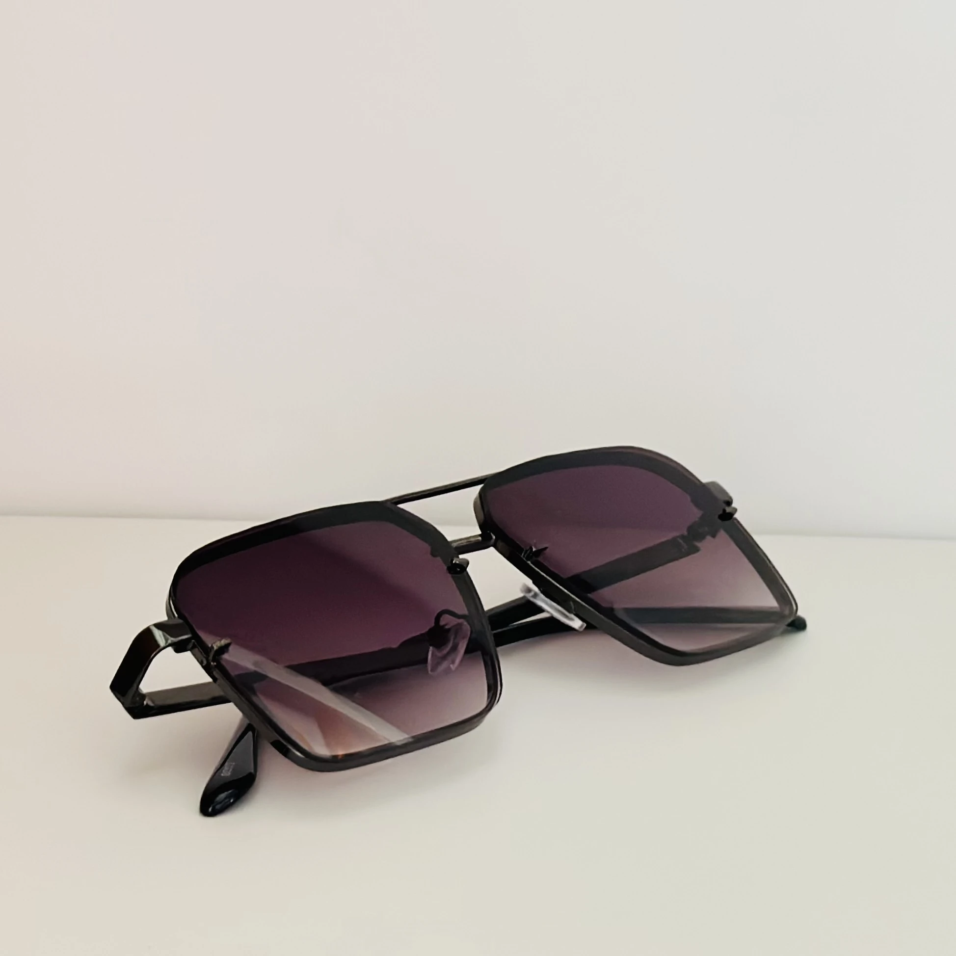 pair of square aviator gradient sunglasses with a black metal frame.
