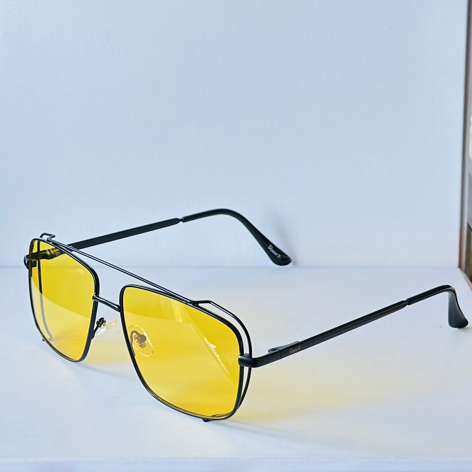 pair of unisex yellow lens square sunglasses featuring a metal frame.