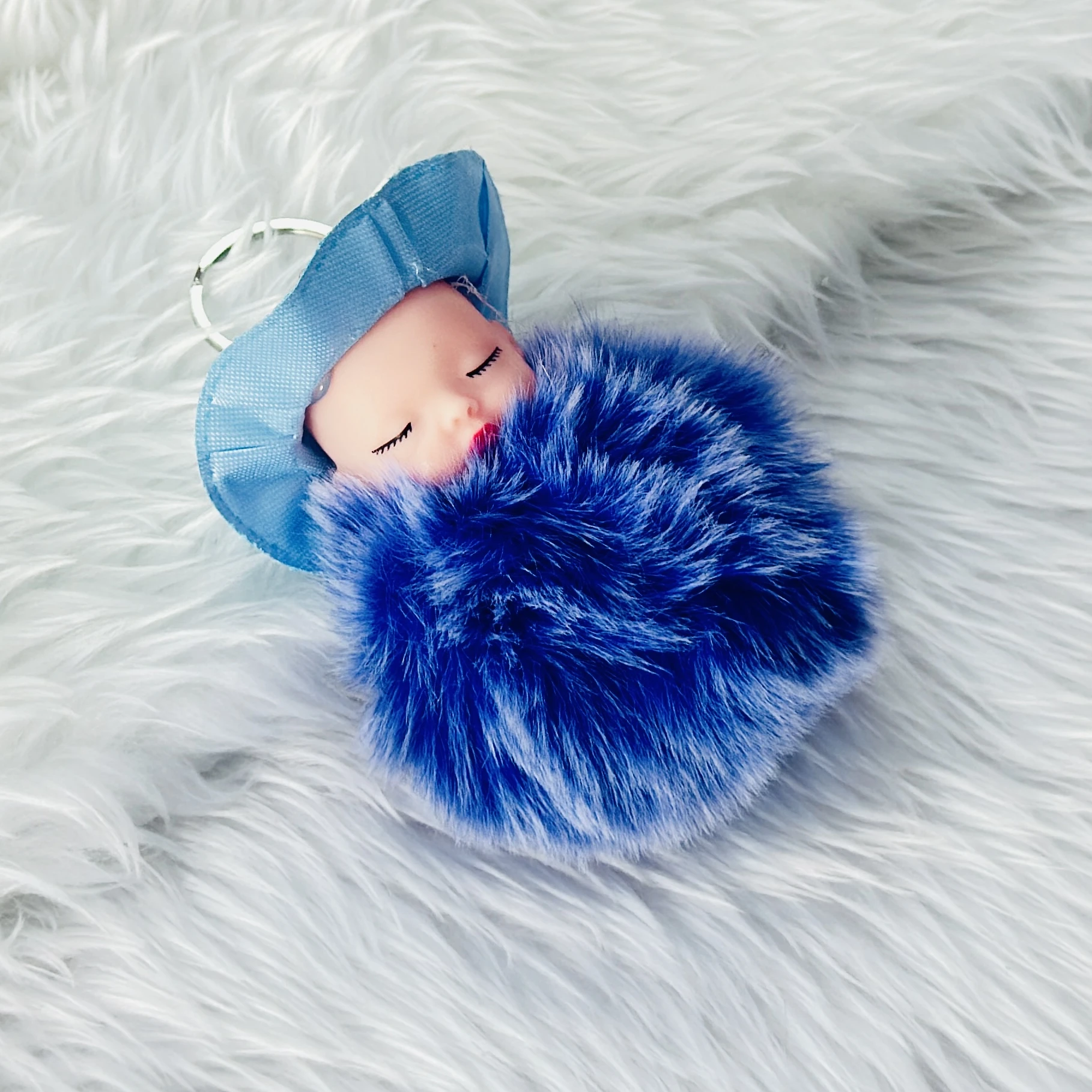 fluffy charm is a red and white SRG sleeping baby doll keychain