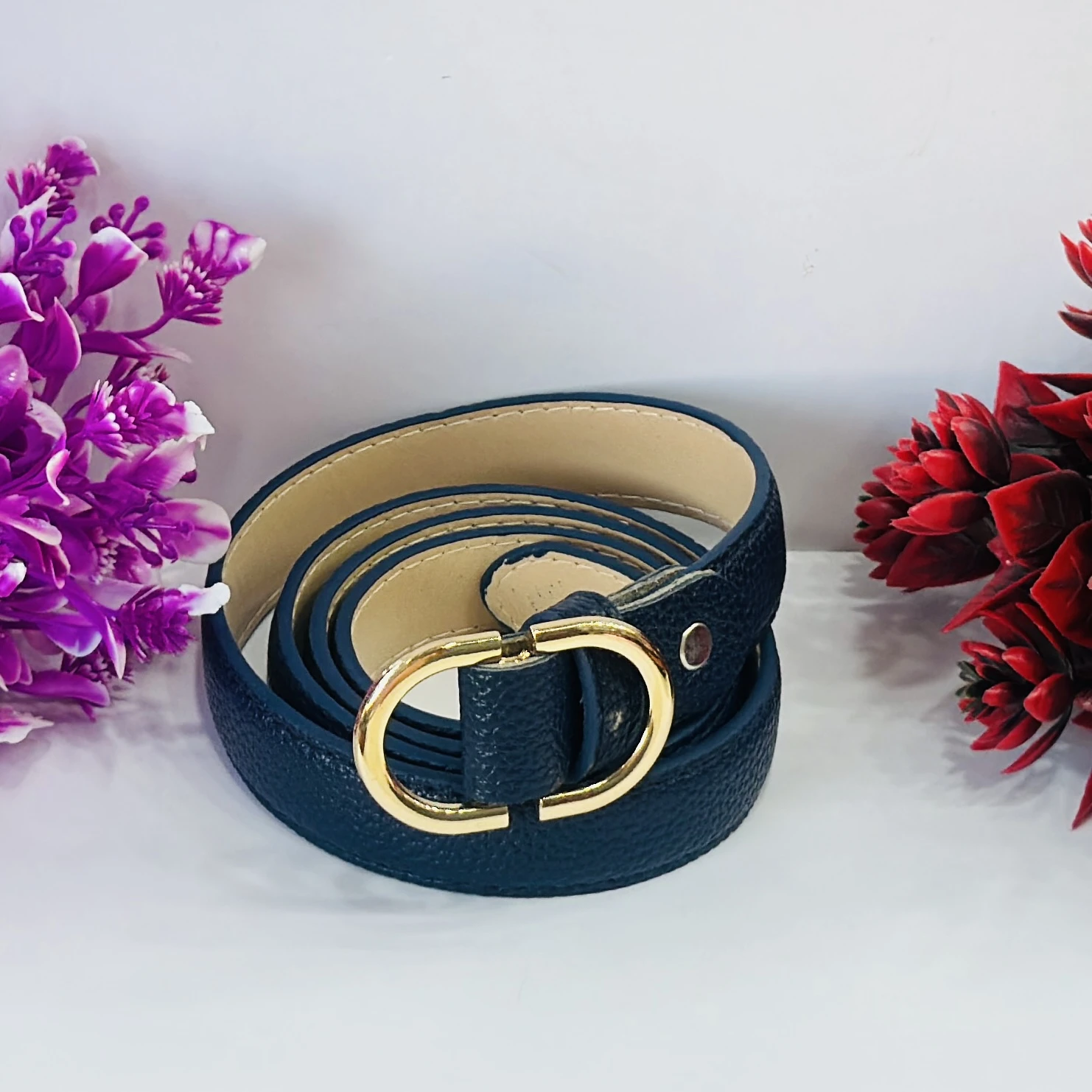Blue women's belt with a gold-tone oval buckle.