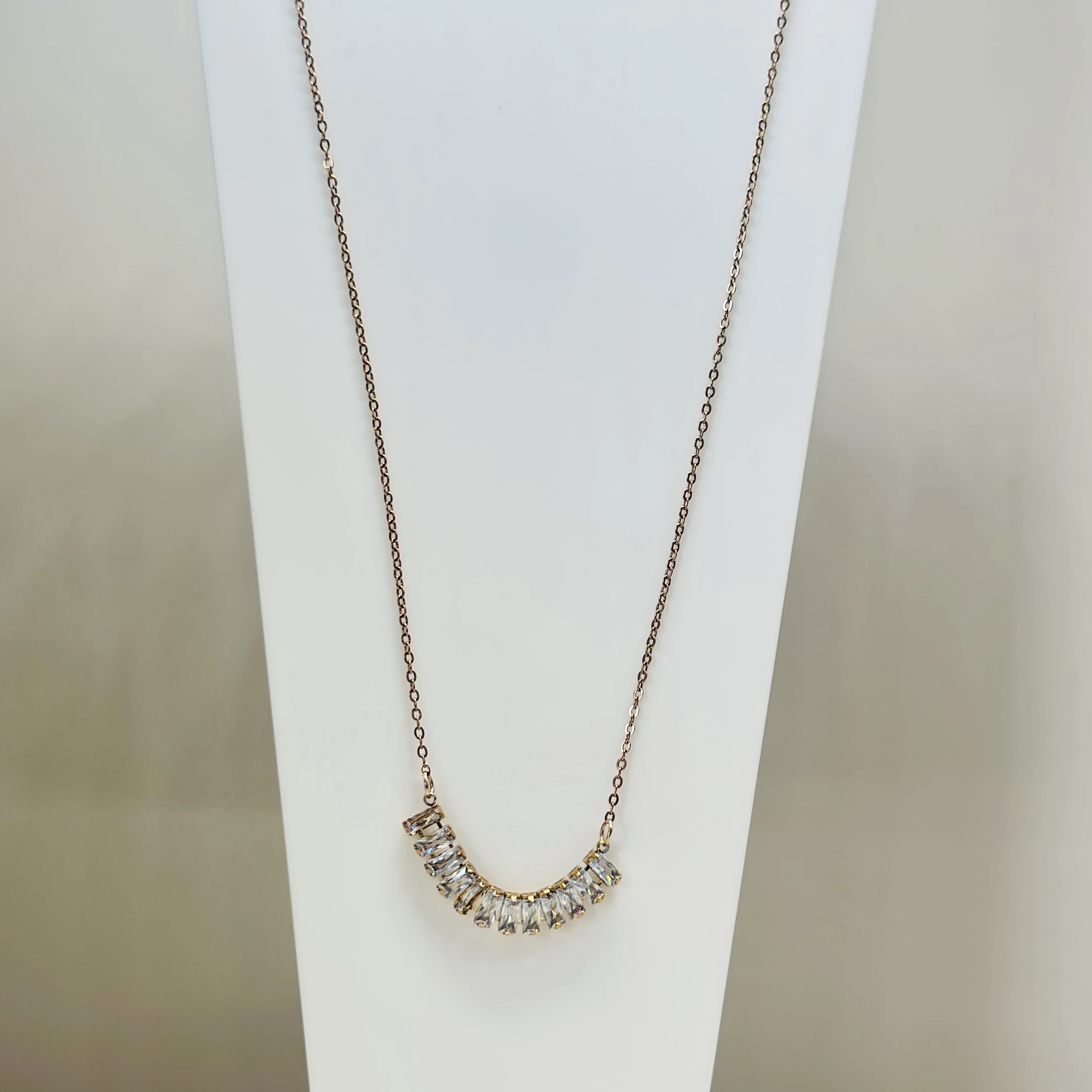 Gold  tone necklace with a curved pendant