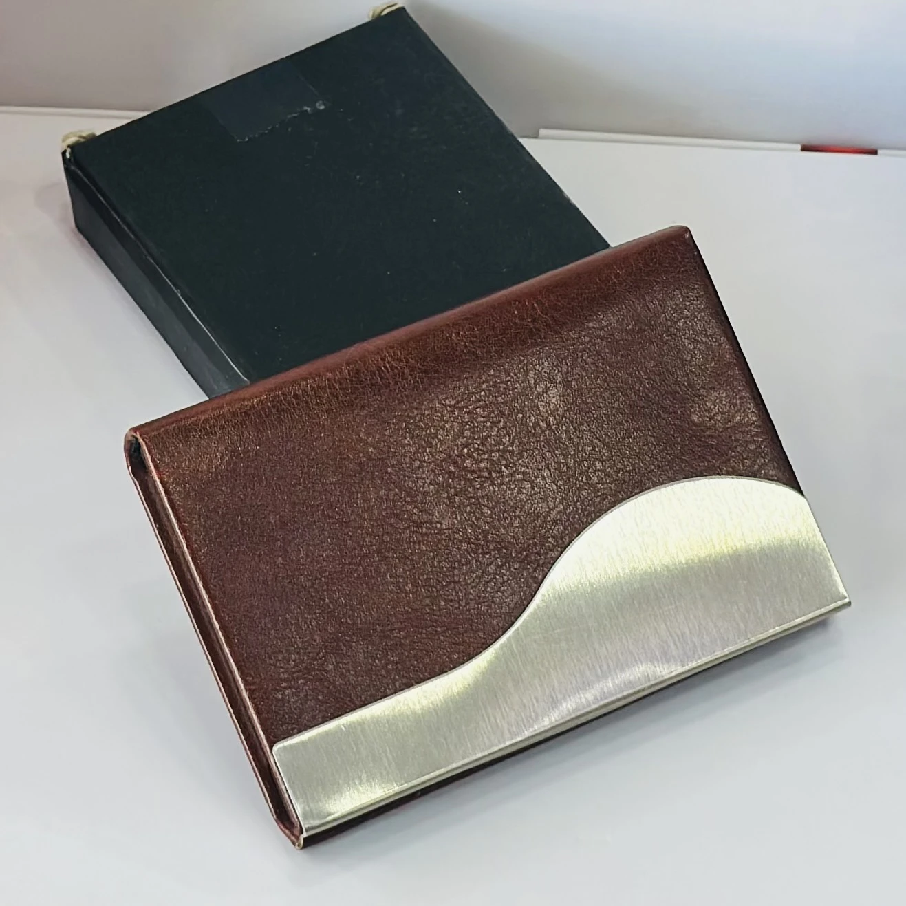 business card holder or card case, likely made of PU leather and stainless steel.