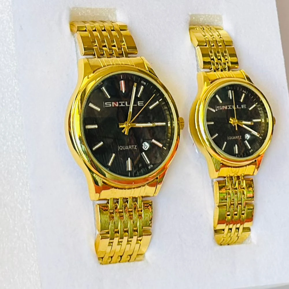 pair of Snille Date Series analog quartz watches for men and women with gold-tone link bracelets and black dials.