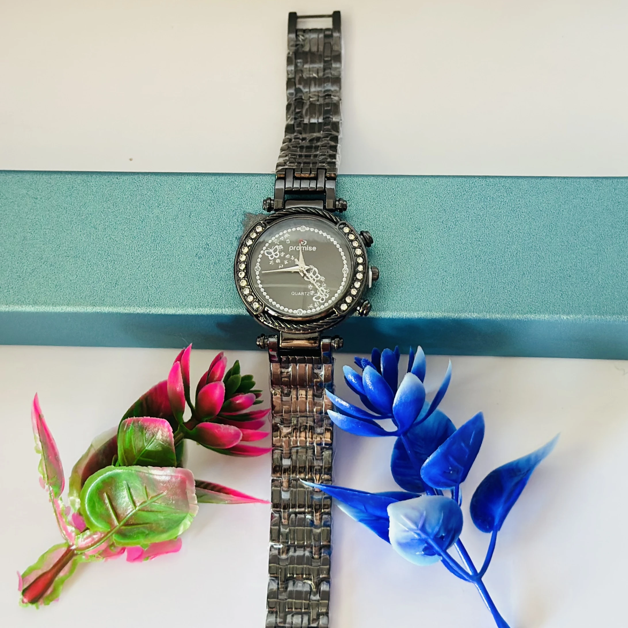 Quartz watch with a black metal band and a rhinestone-studded bezel.