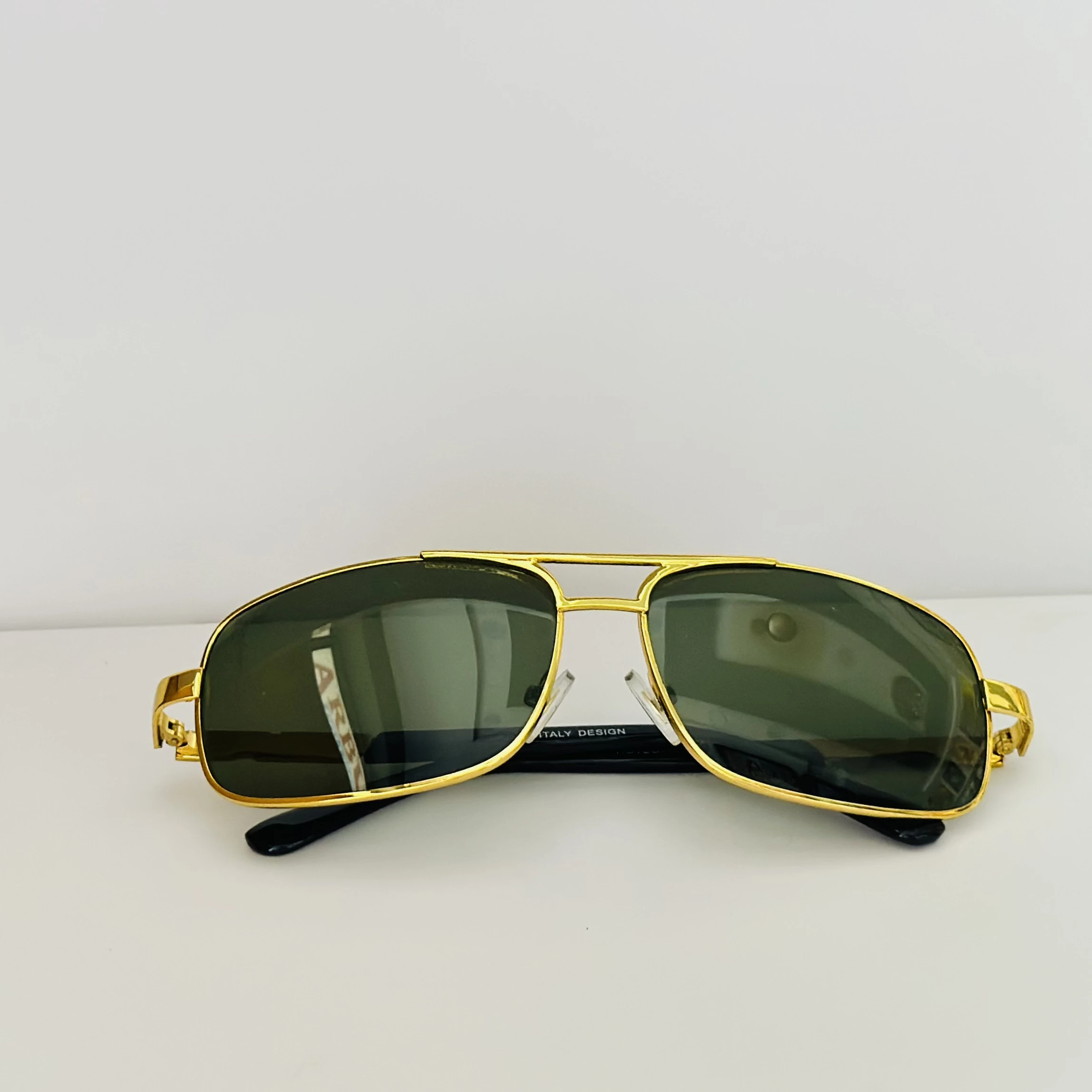 Gold aviator-style sunglasses with green lenses.