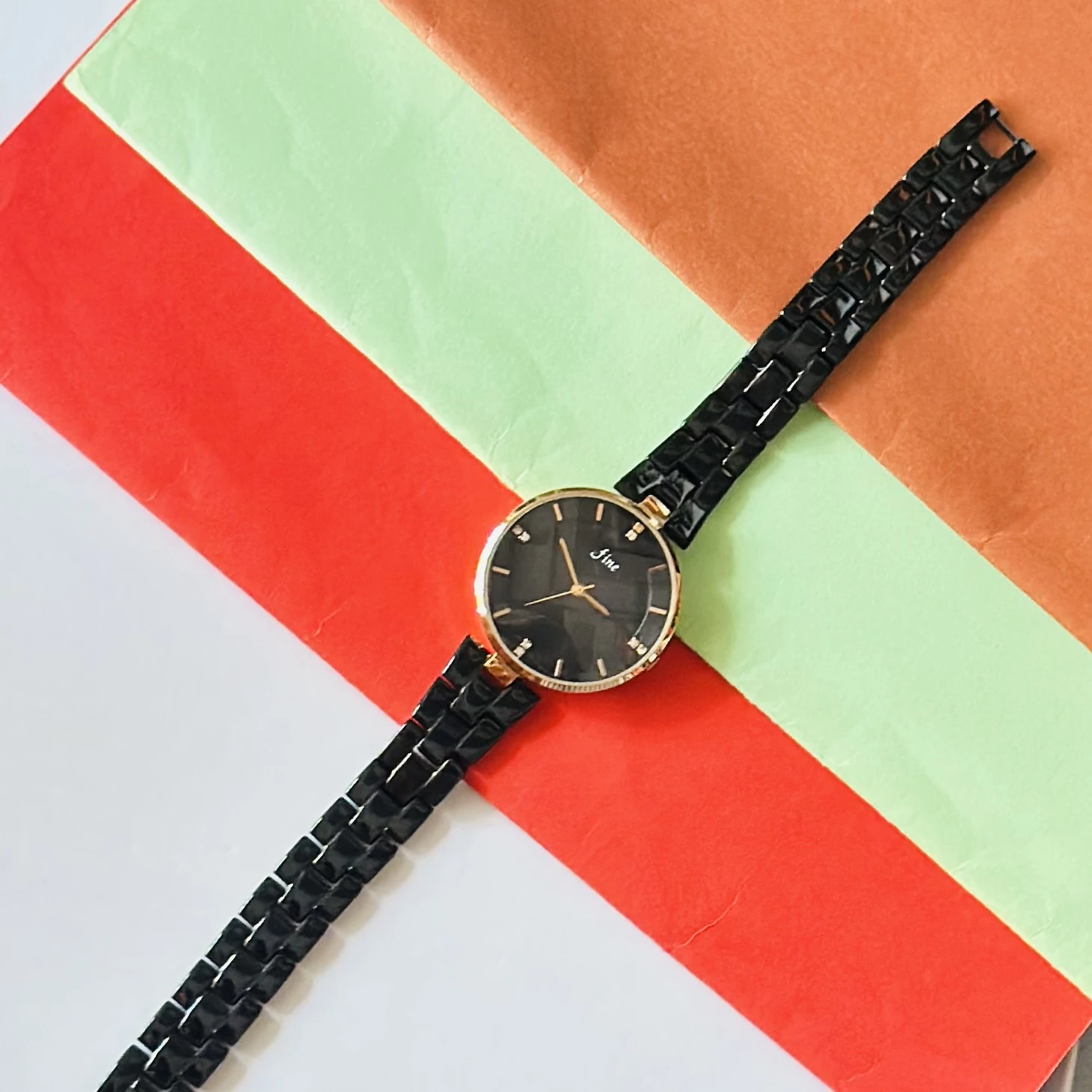 LeForce analog women's watch with a black dial, gold-plated case, and black bracelet strap