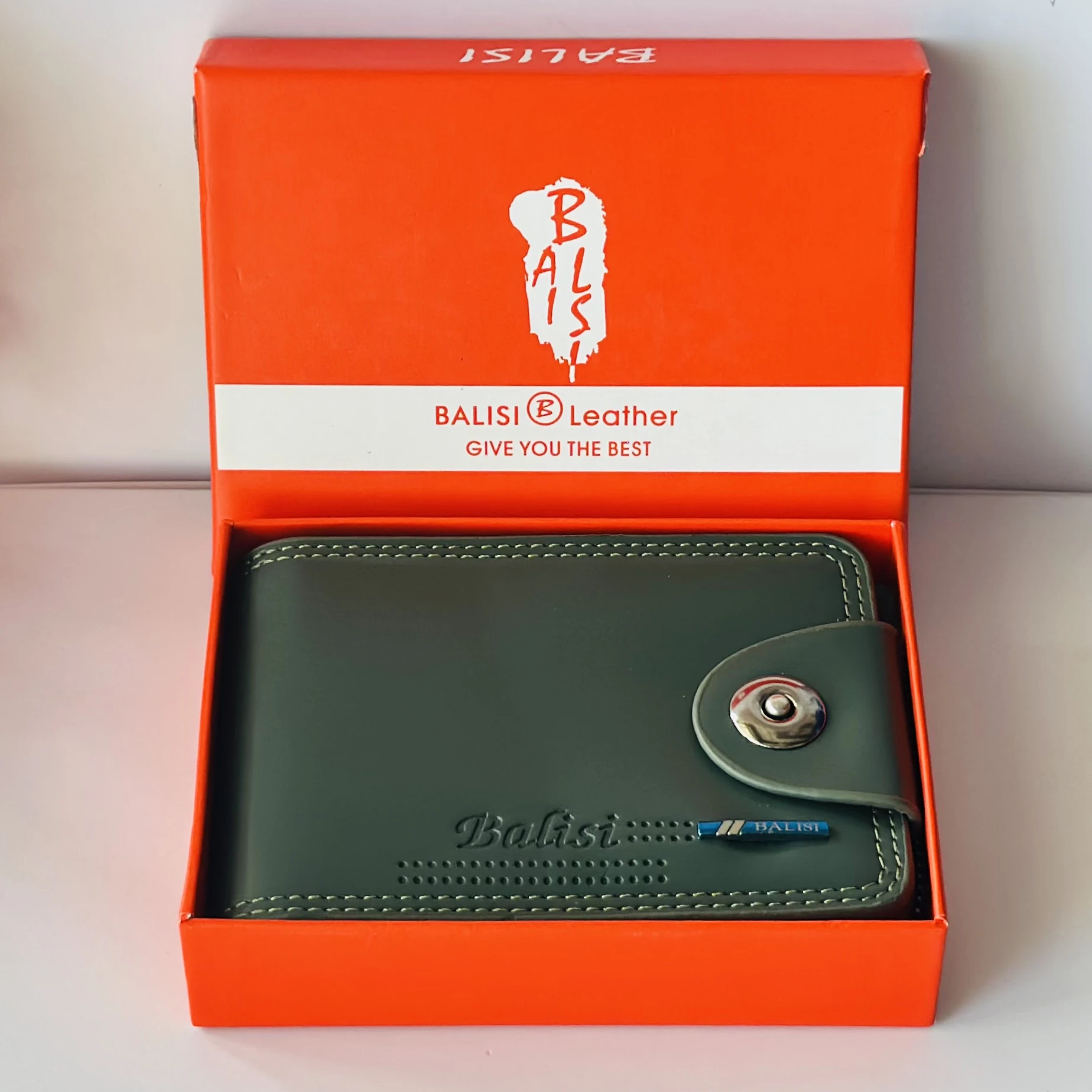 Balisi bifold leather wallet in green with a button closure.