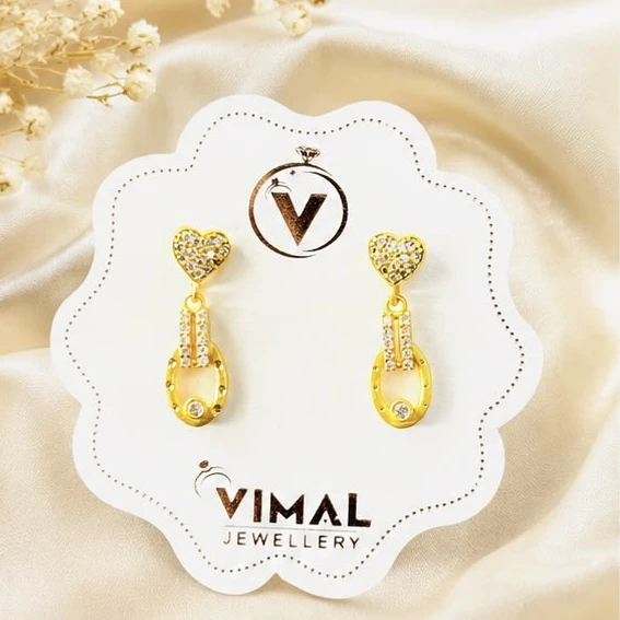 gold earrings feature a heart-shaped stud studded with white stones and a dangling oval charm