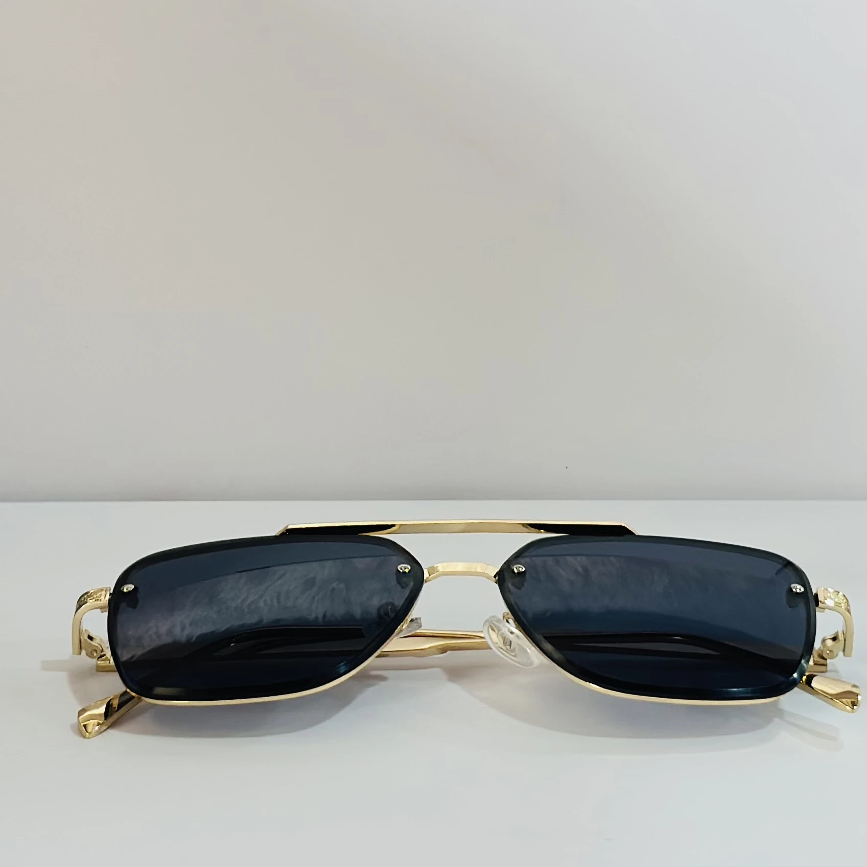 pair of Versace VE 2275 sunglasses with a gold metal frame and black/grey lenses.
