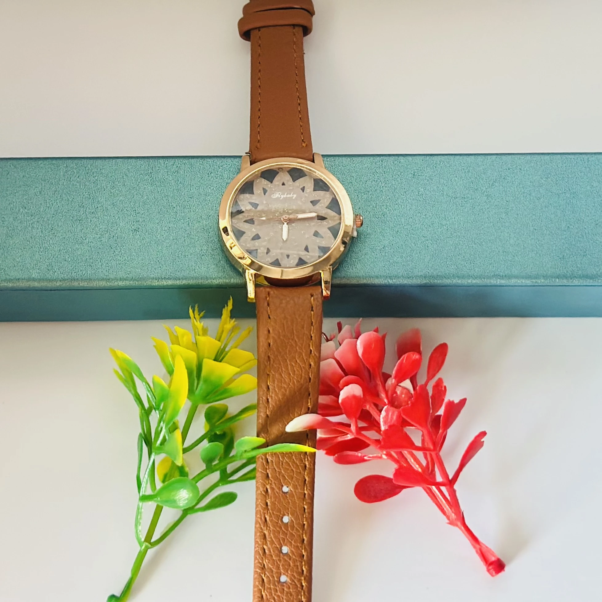 Flybaby flower watch with a peach/tan faux leather strap.