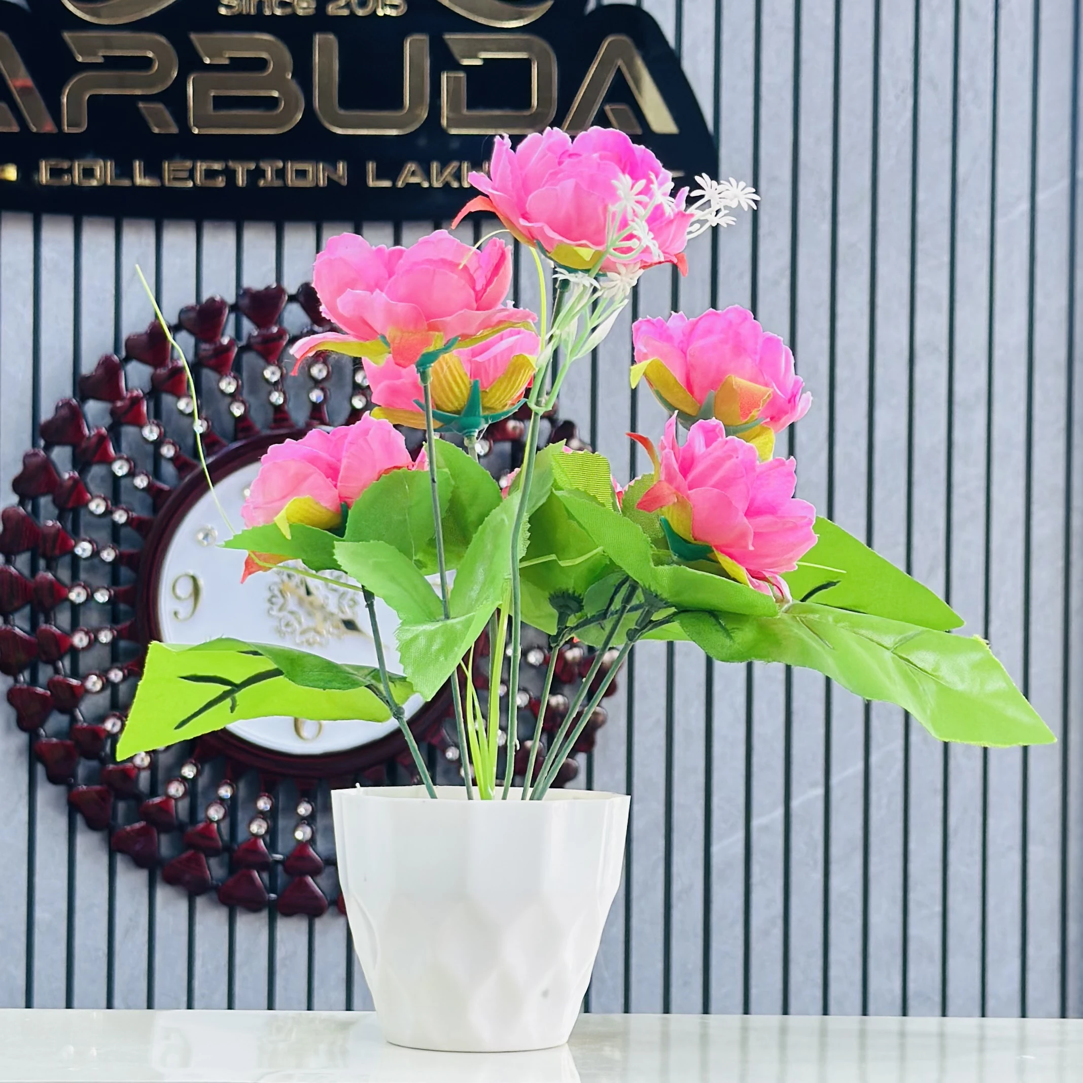 Pink  lotus flower arrangement in a white pot.