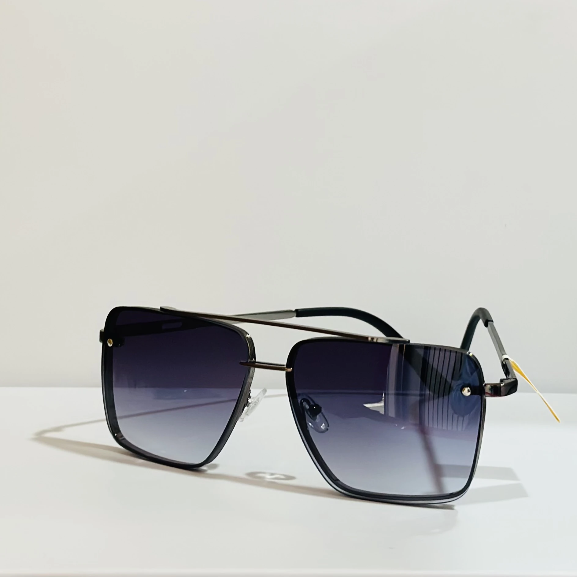 pair of square aviator sunglasses with a black metal frame and gradient lenses.