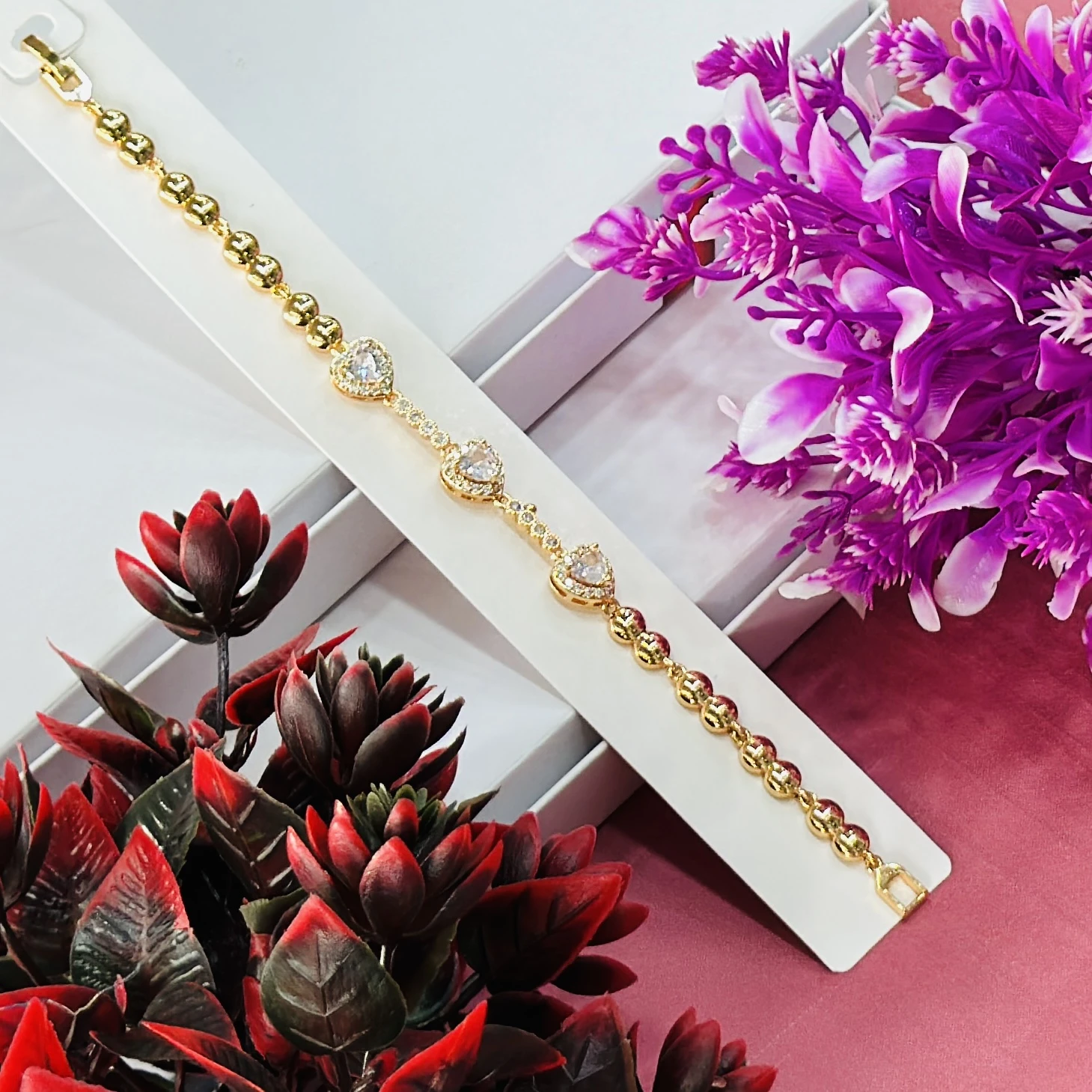 Gold plated women's bracelet with a heart design and cubic zirconia stones.