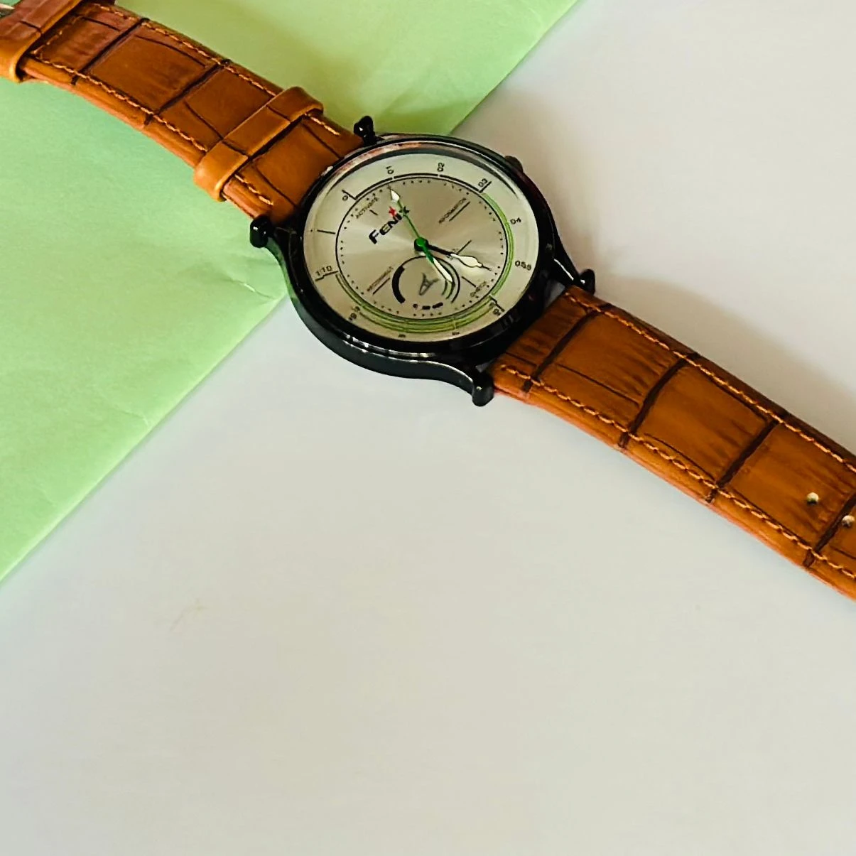 Round  analog watch with a brown leather strap