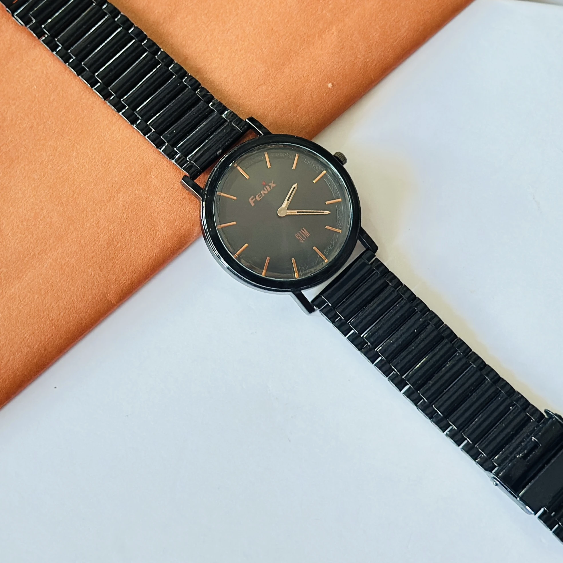 Fenix Slim black analog wristwatch with a matching metal band.