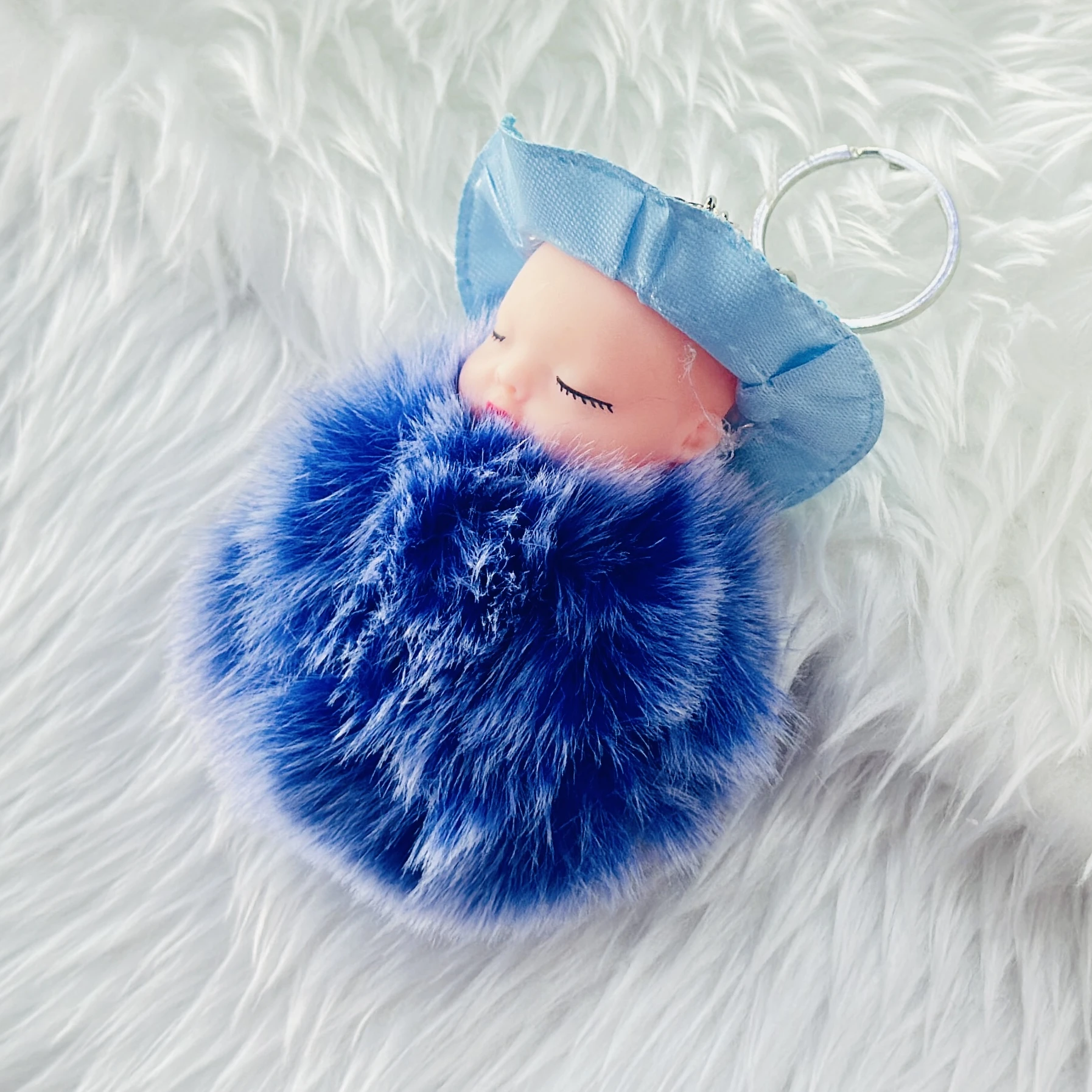 fluffy charm is a red and white SRG sleeping baby doll keychain