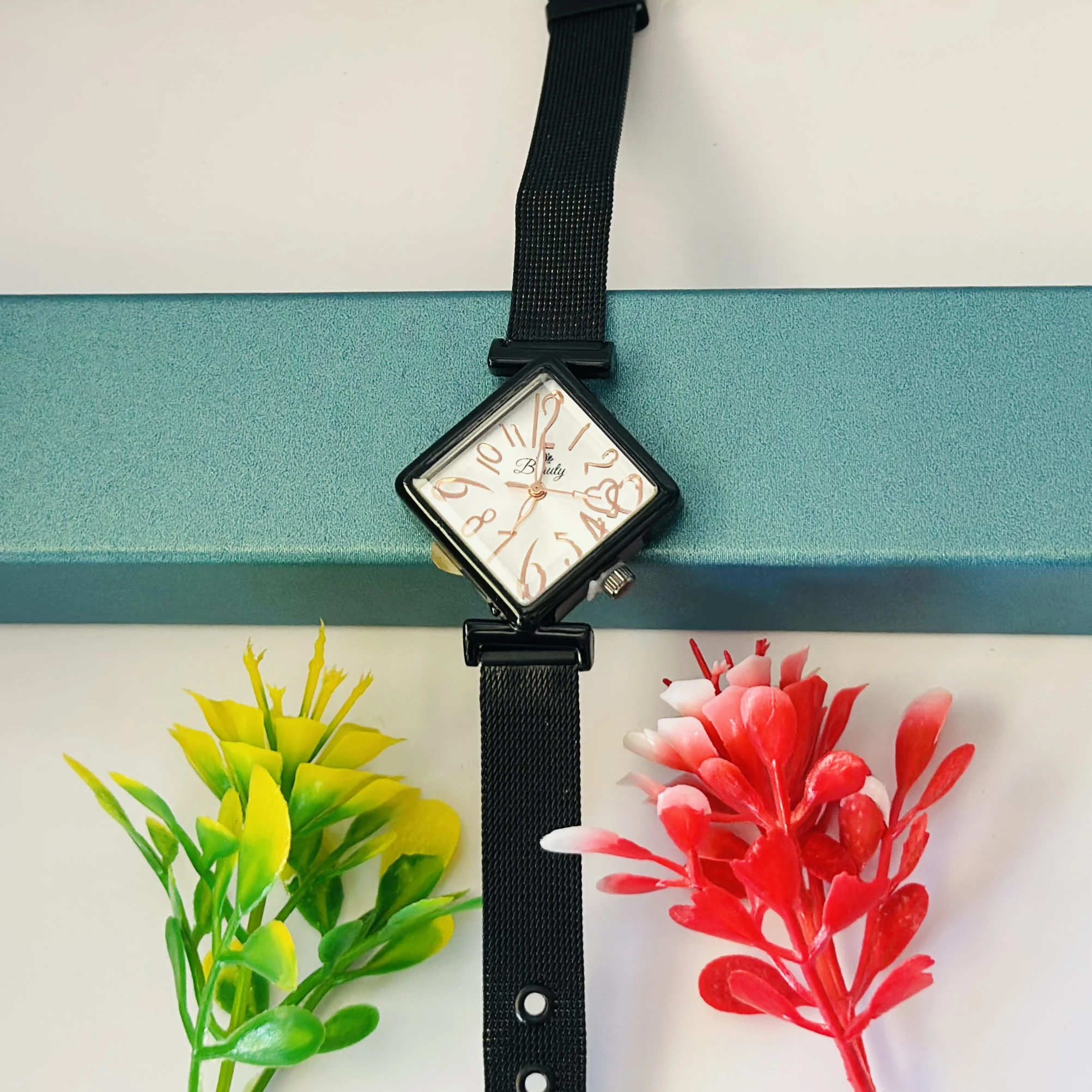 Black mesh strap watch with a square face.